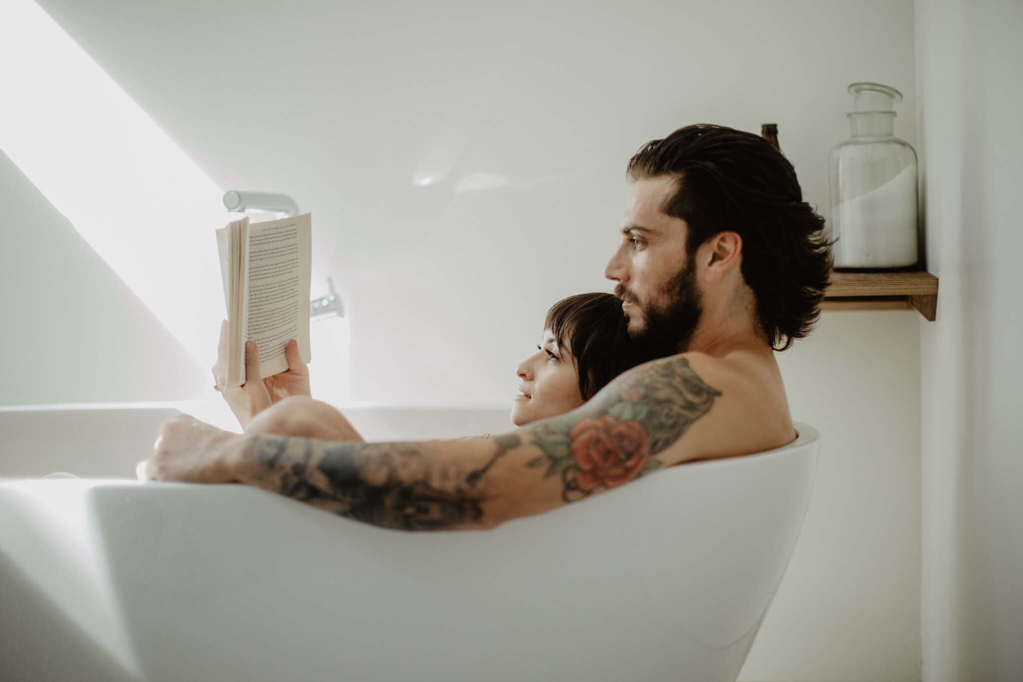 Boudoir tattooed couple reading in bath