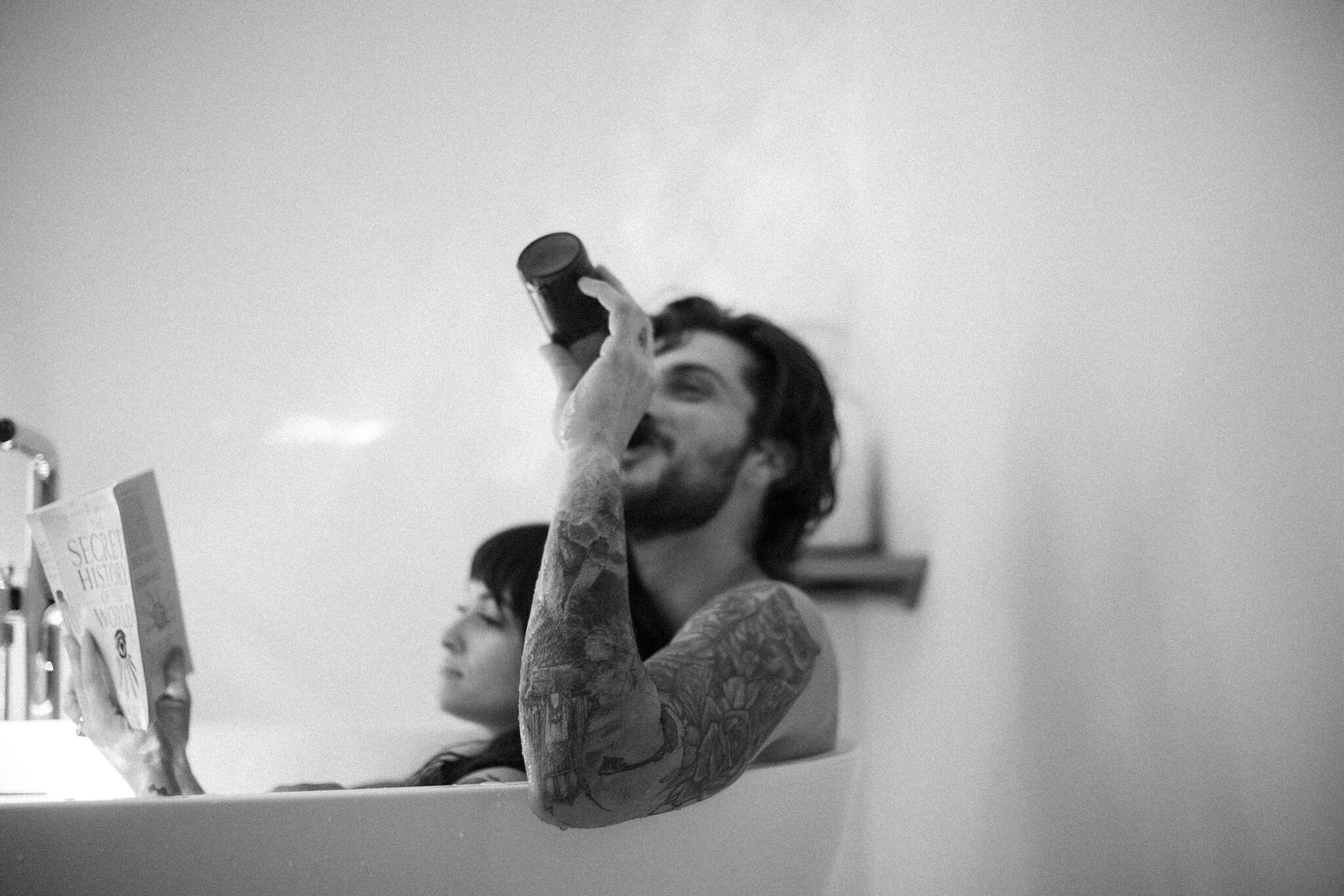 Black and white shot of tattooed couple in bath