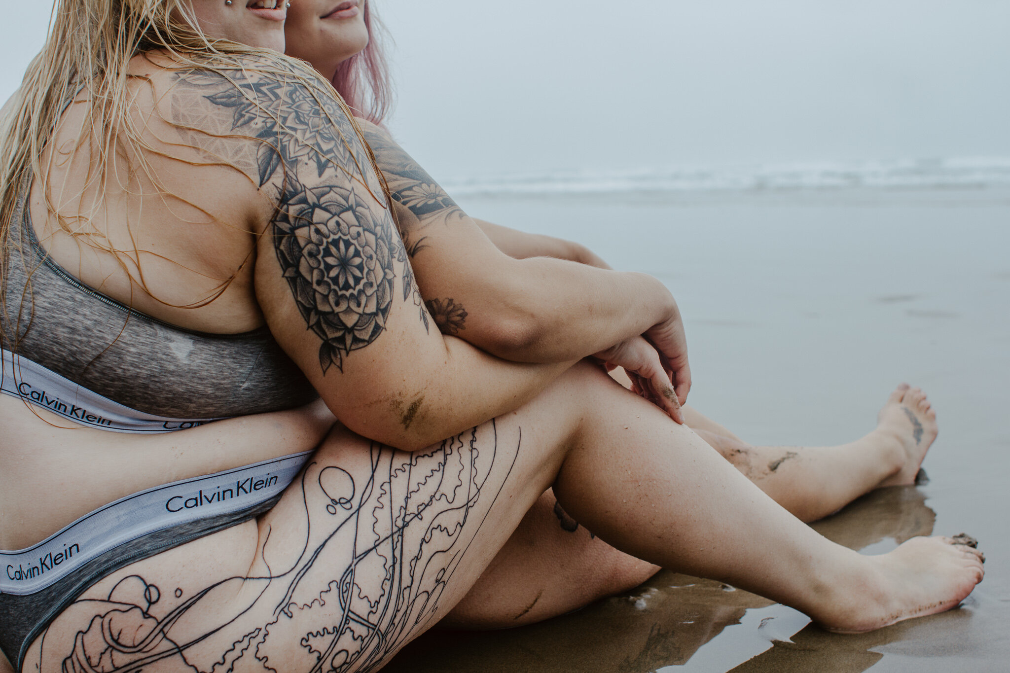 Tattooed lesbian couple at beach