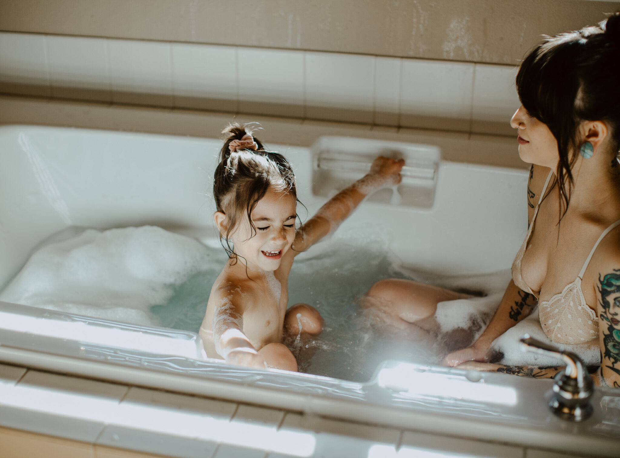Mother and child in tub with bubbles