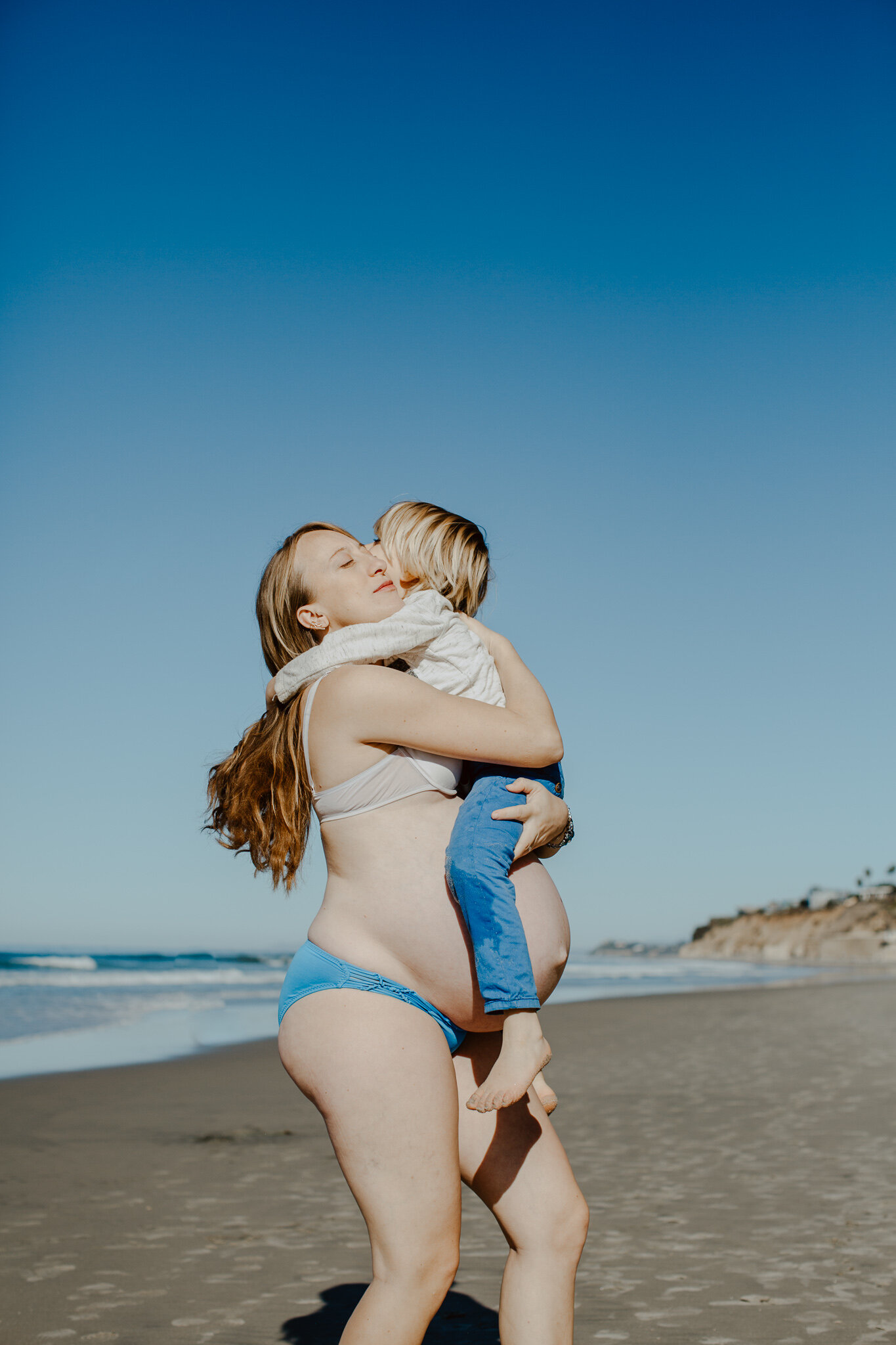 Pregnant mother with child on beach