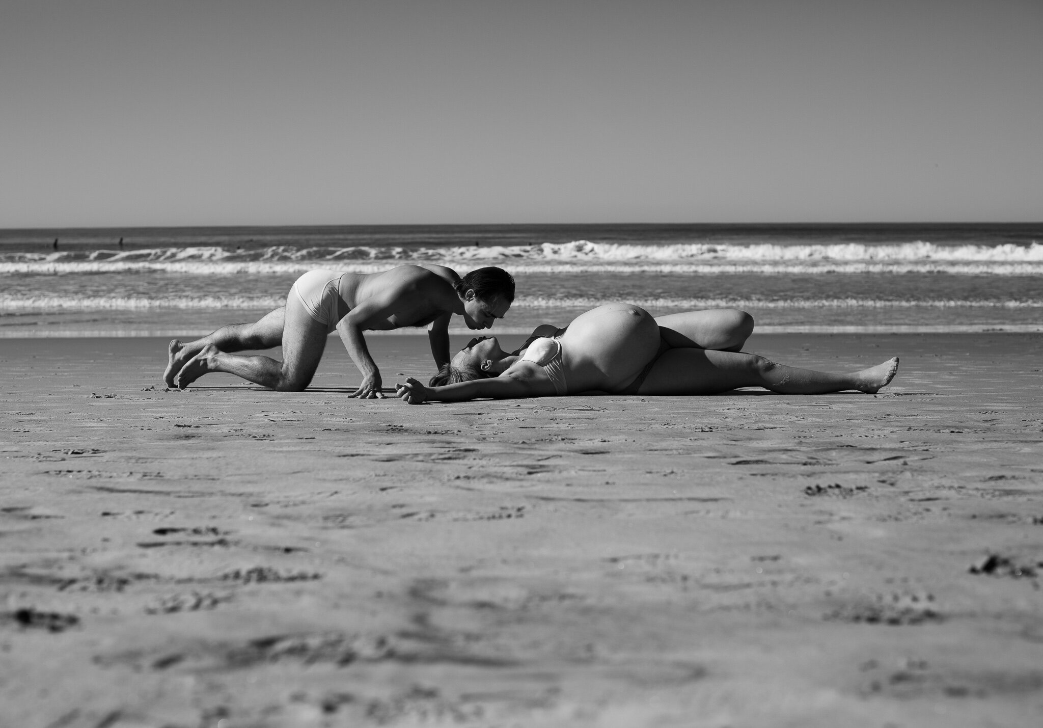 Husband kissing pregnant wife on beach