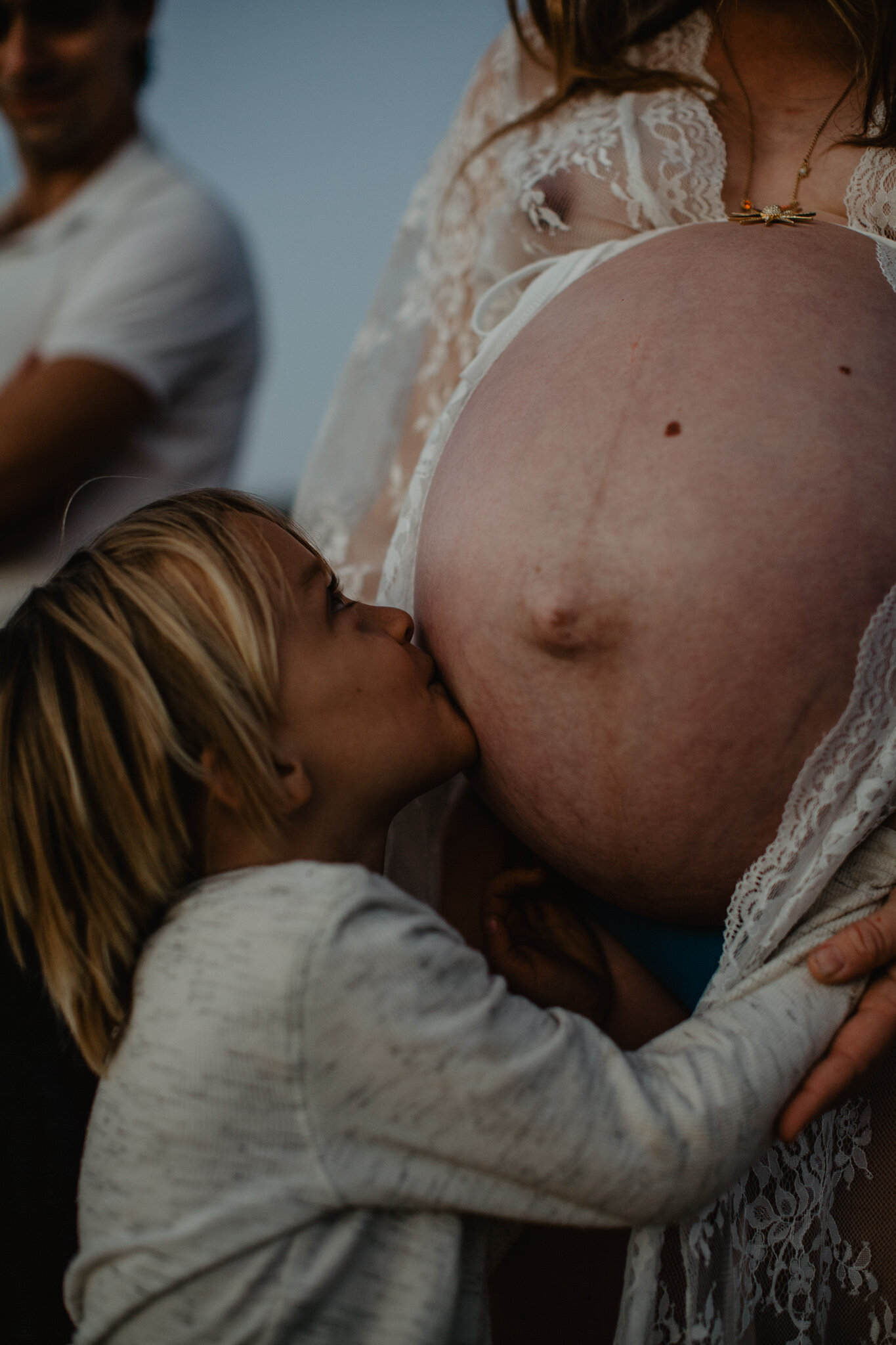 Kid kissing mom's pregnant stomach