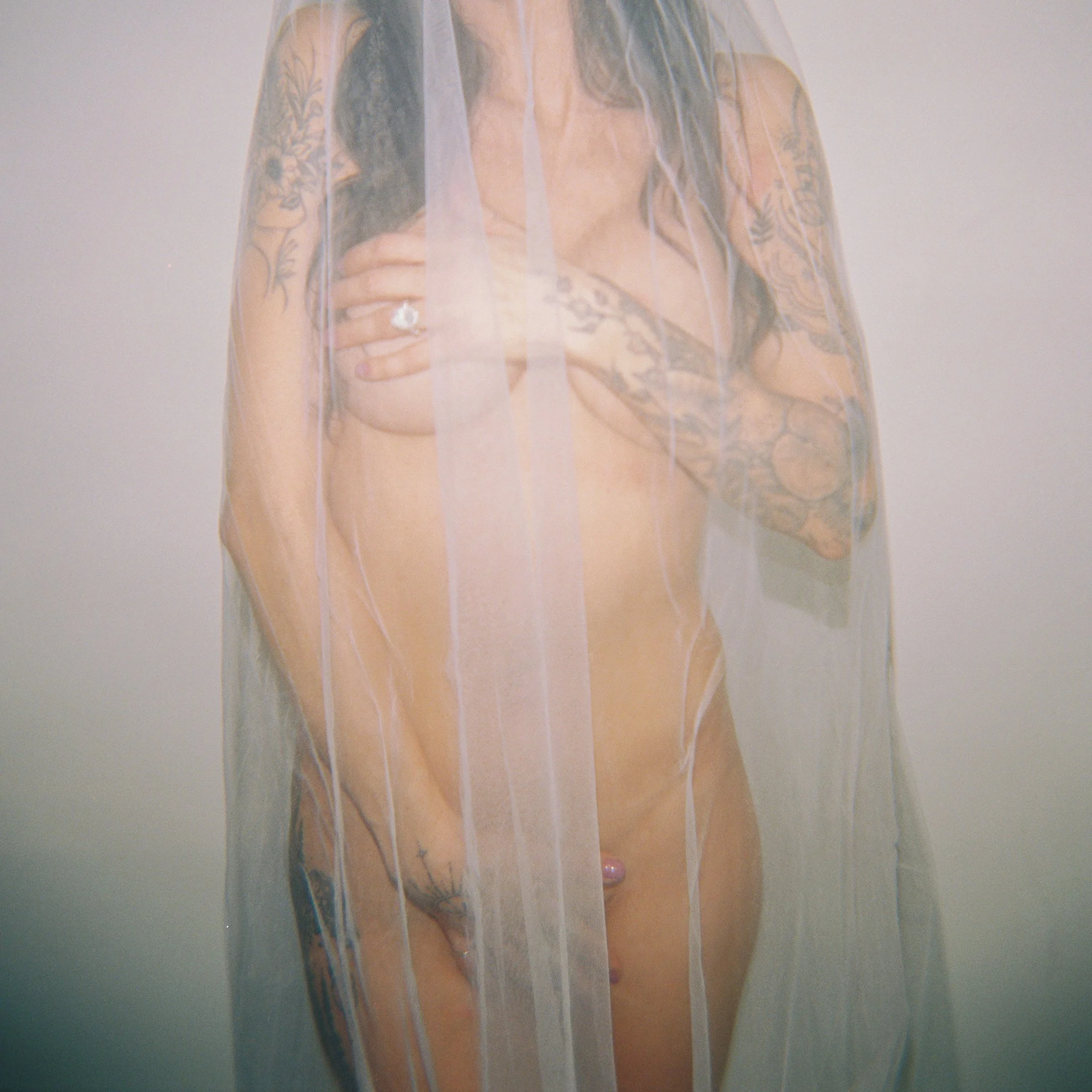 Bridal boudoir woman wearing nothing but her wedding ring and her veil