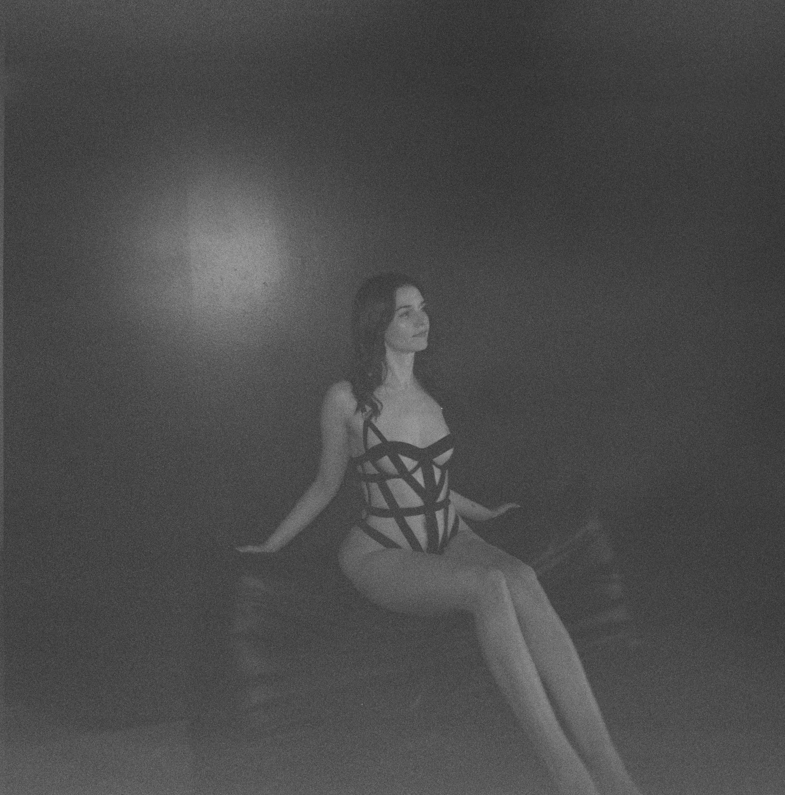 Black and white 120 Film with woman sitting in black lingerie on the back of a chair
