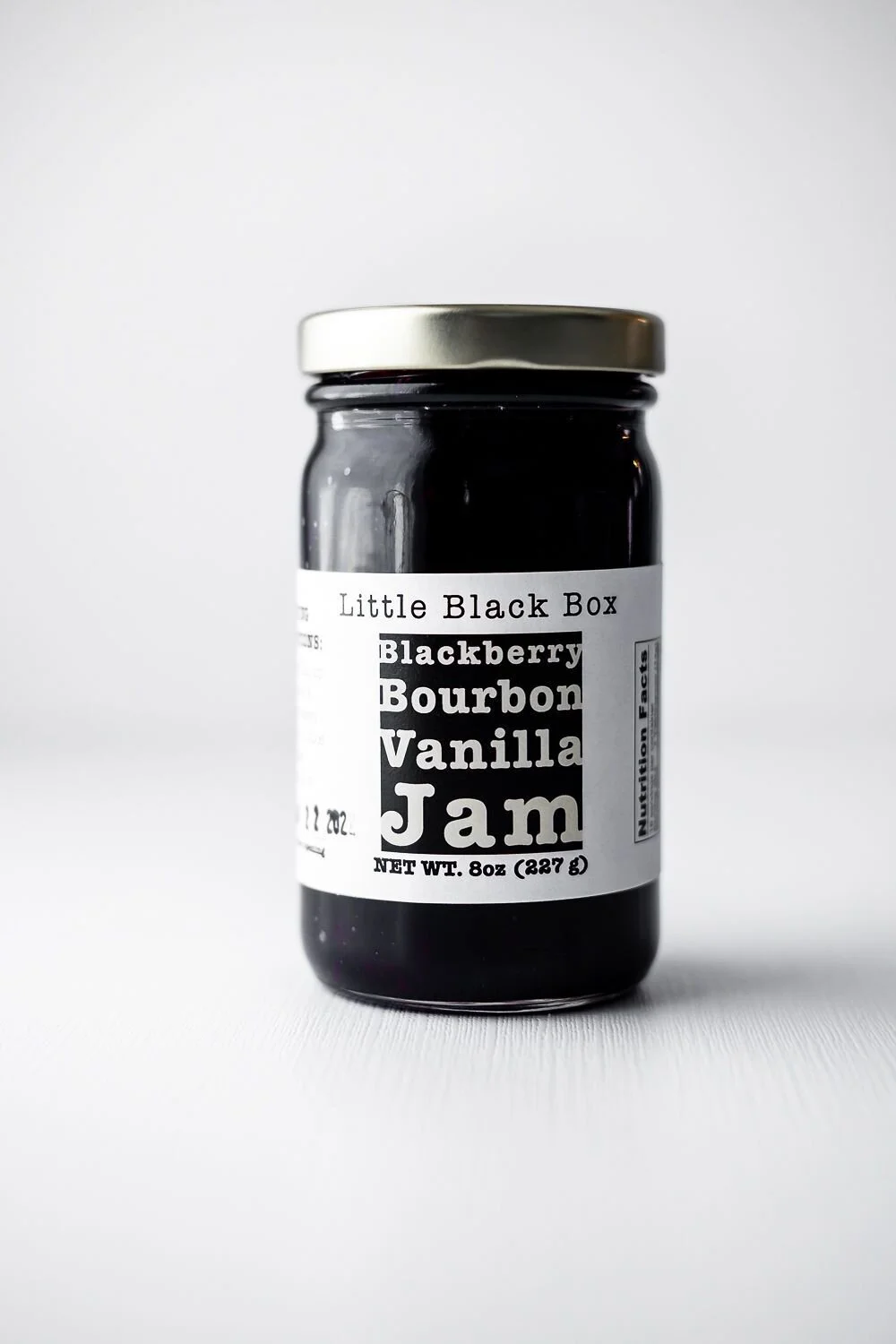 Single jar of Blackberry Bourbon Vanilla Jam on white background.