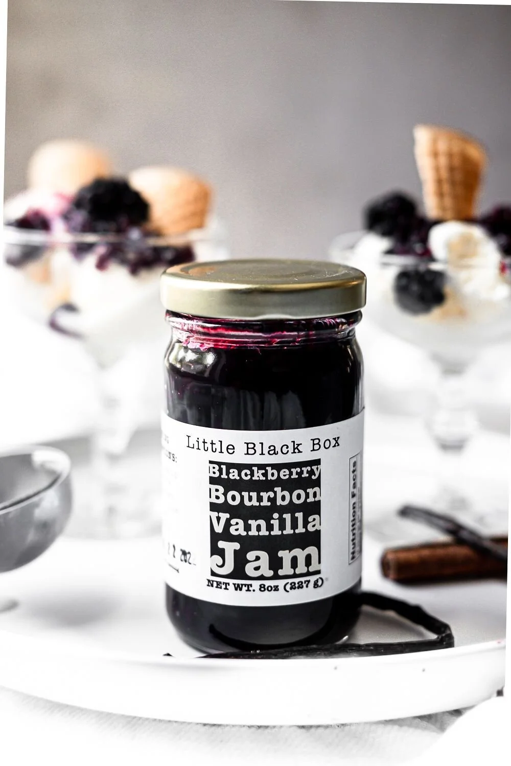 small batch homemade blackberry bourbon vanilla jam.  Jam mixed ice cream in the background.