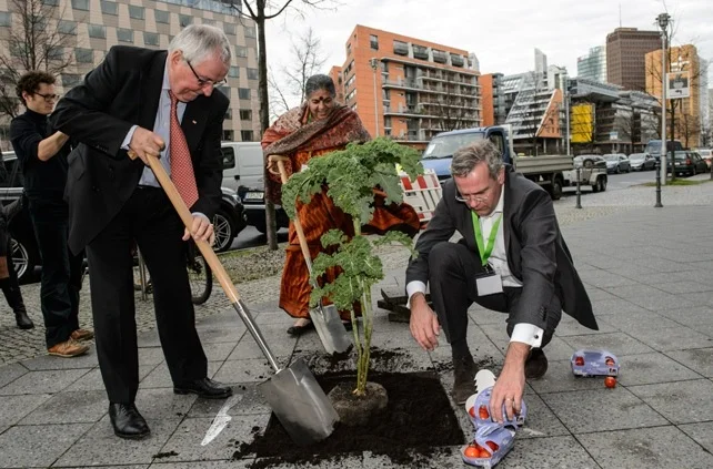Global Soil Week attendees get down and dirty, putting a plant on a city sidewalk. Photo from Global Soil Week website's photo gallery .