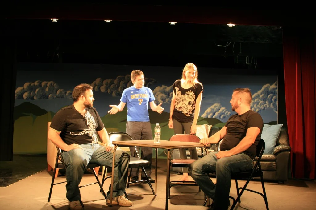 Jake (Tim Moran), far right, tries to explain the importance of jigsaw puzzles to his friends (l to r, Damian Gaeta, Patrick Lavery, Michelle Wood, and on the couch, Emily O'Sullivan) in Puzzle Theory