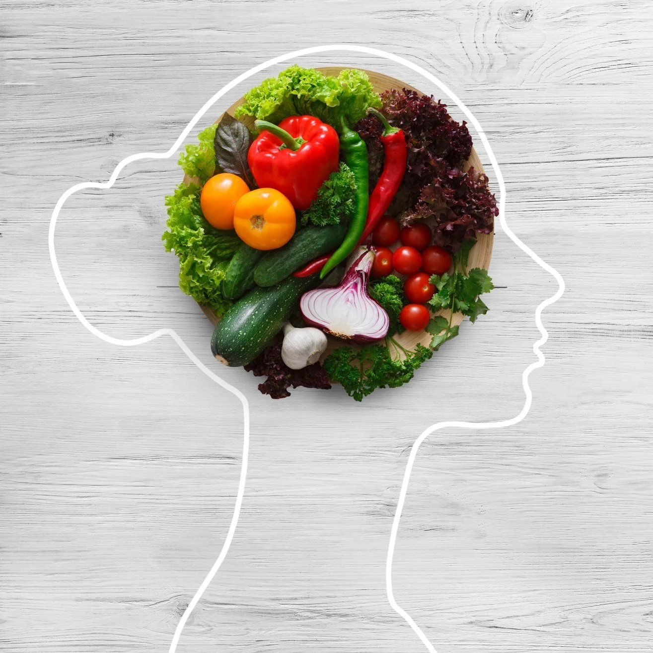 A digital illustration of a human head in profile outline with a bowl of fresh vegetables inside the head area, including tomatoes, bell peppers, cucumbers, garlic, onion, and various greens, set against a light wood-textured background.