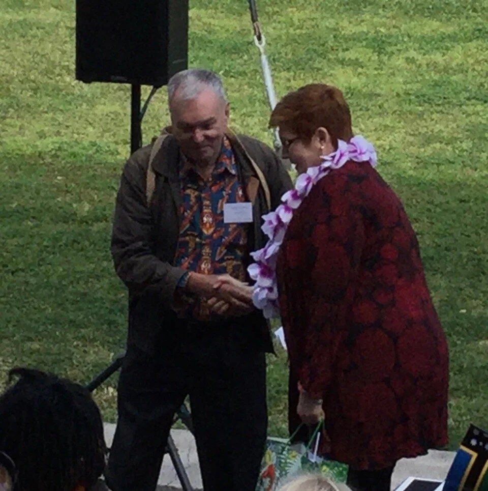 Clive Moore handing his bibliography to Marise Payne