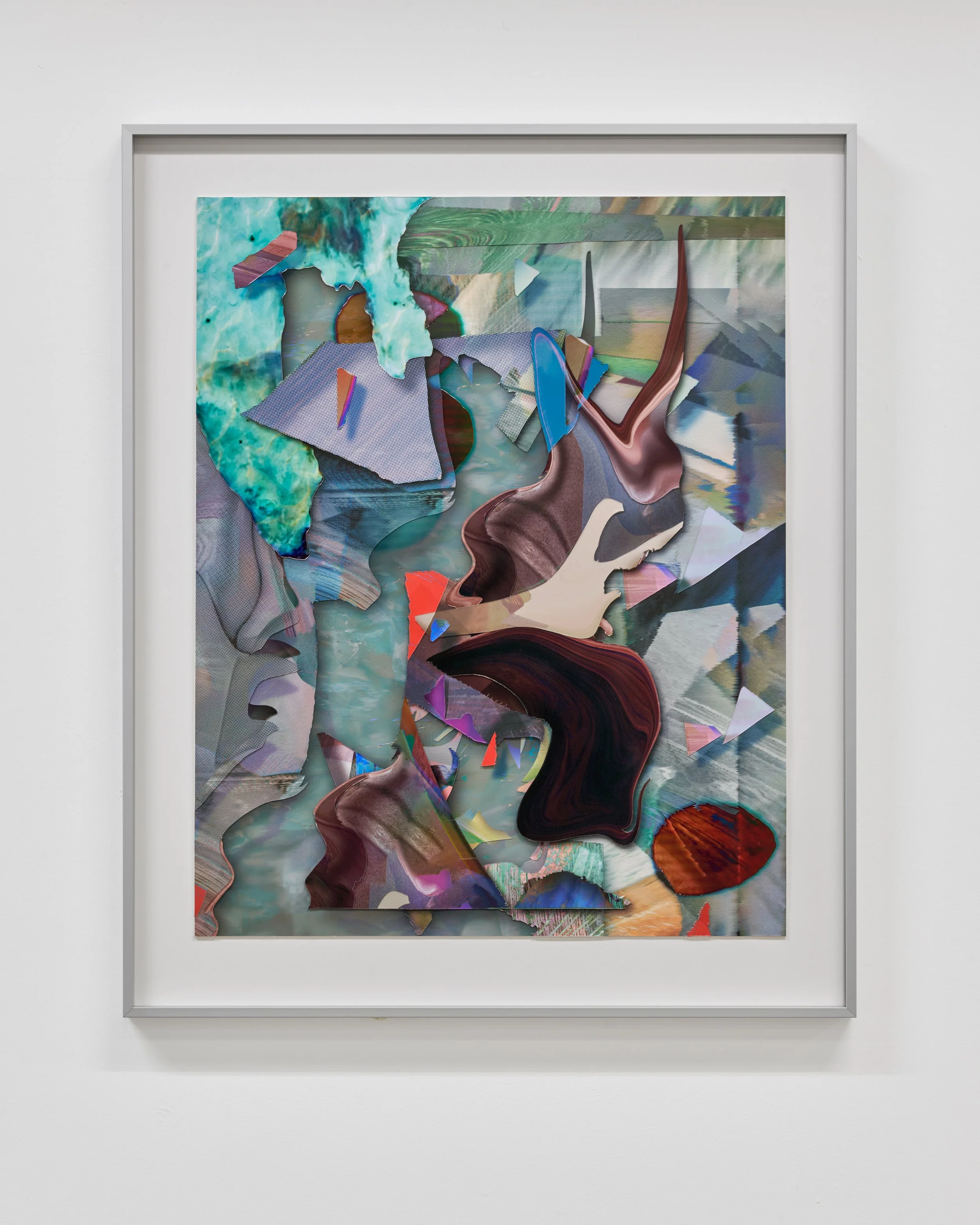 An abstract mixed media artwork with colorful, irregularly shaped paper and fabric pieces collaged onto a canvas, displayed in a silver frame on a white wall.