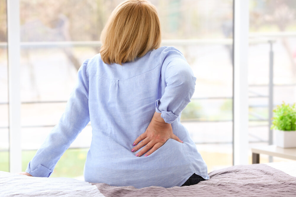 Senior woman suffering from backache at home