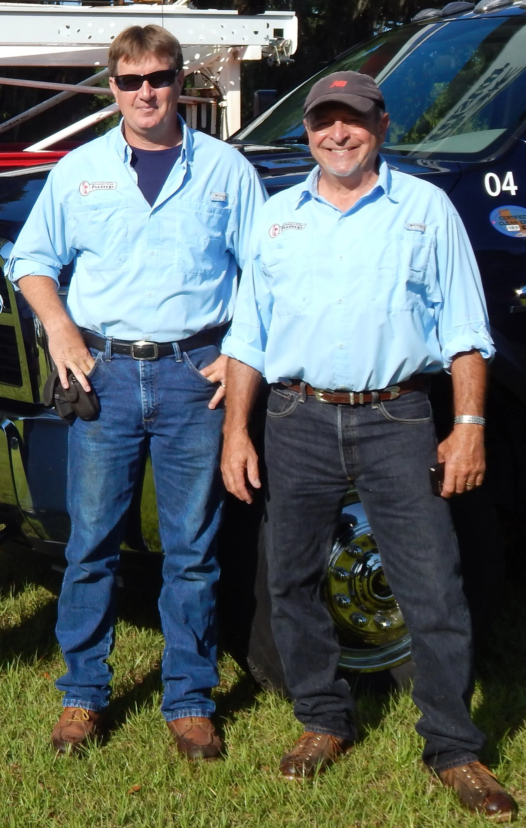 Image of owner Steve Briel and former owner Dennis Macaluso standing in front of the service truck, in June 2013