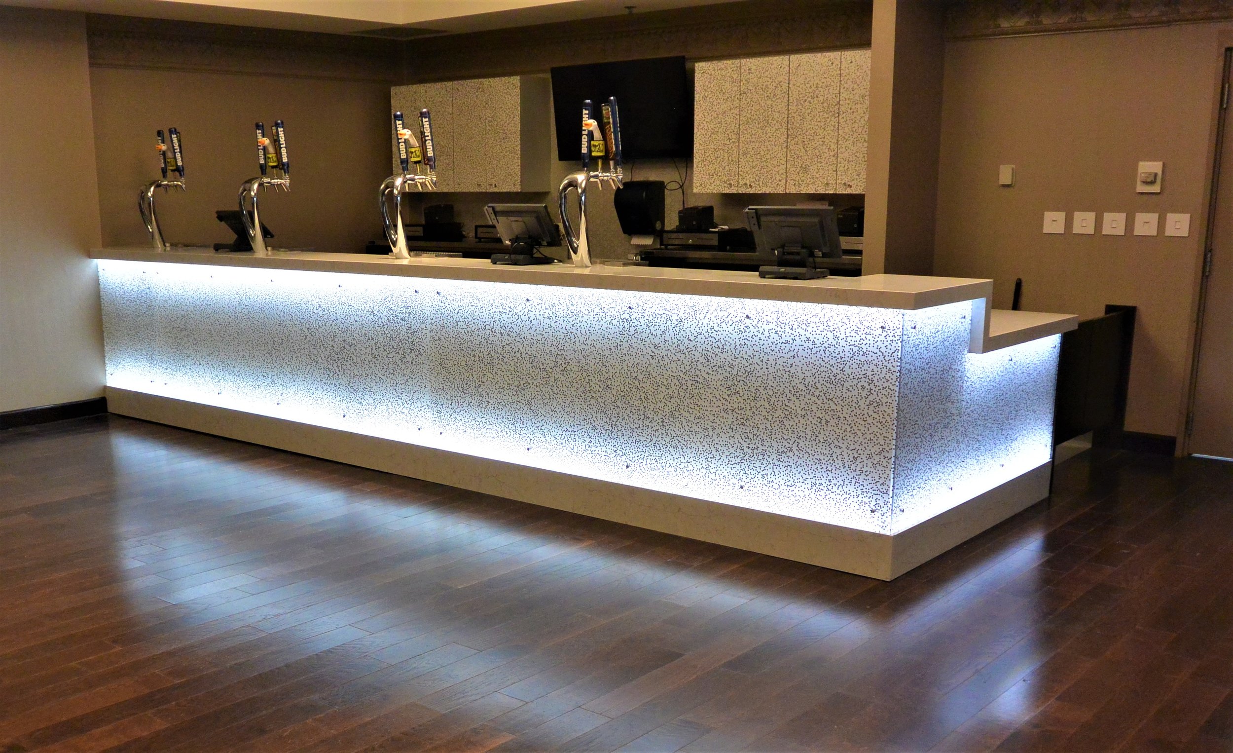  This illuminated bar with quartz counter top makes an inviting fixture for beverage service.  
