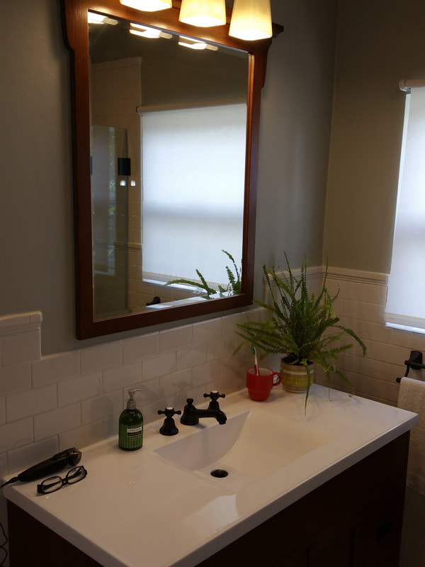  New vanity, light & mirror accented with a tile wainscotting.
 