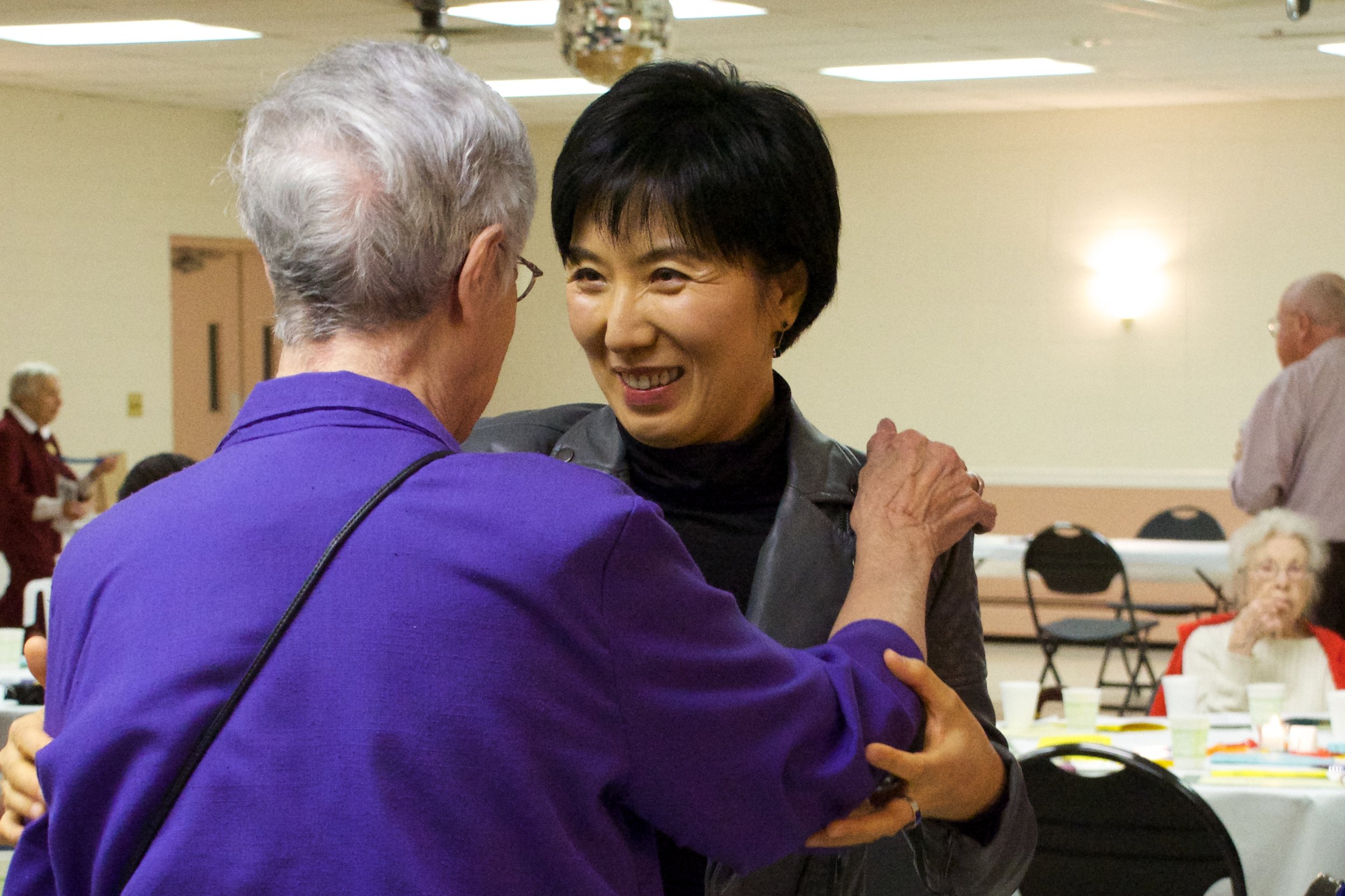 A volunteer greets a student at an event