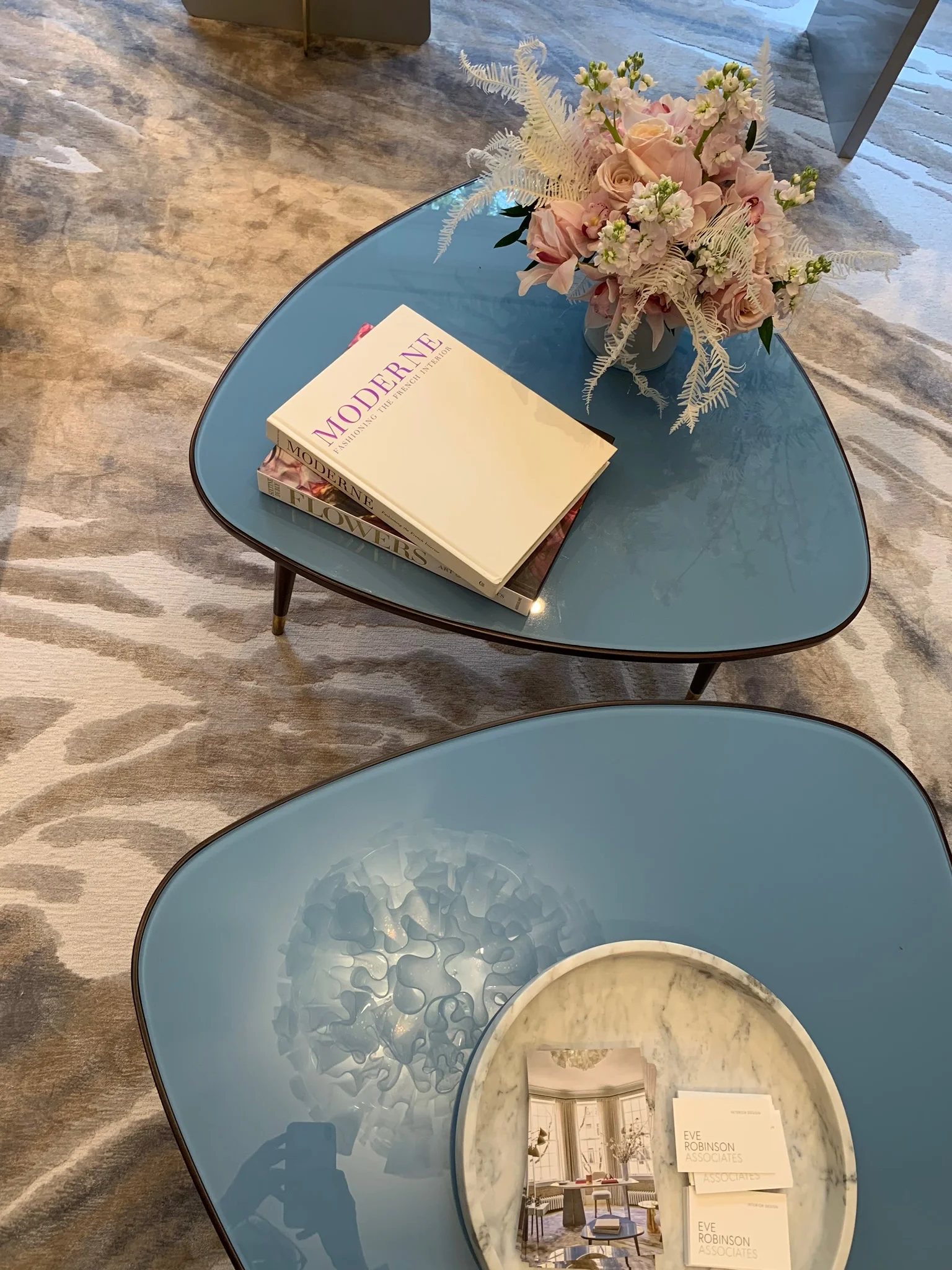 Another Jeff Zimmerman light fixture by R & Company is reflected in the vintage triangular coffee table ( Van Den Akker Antiques ) in Eve Robinson’s feminine bedroom-turned-office.