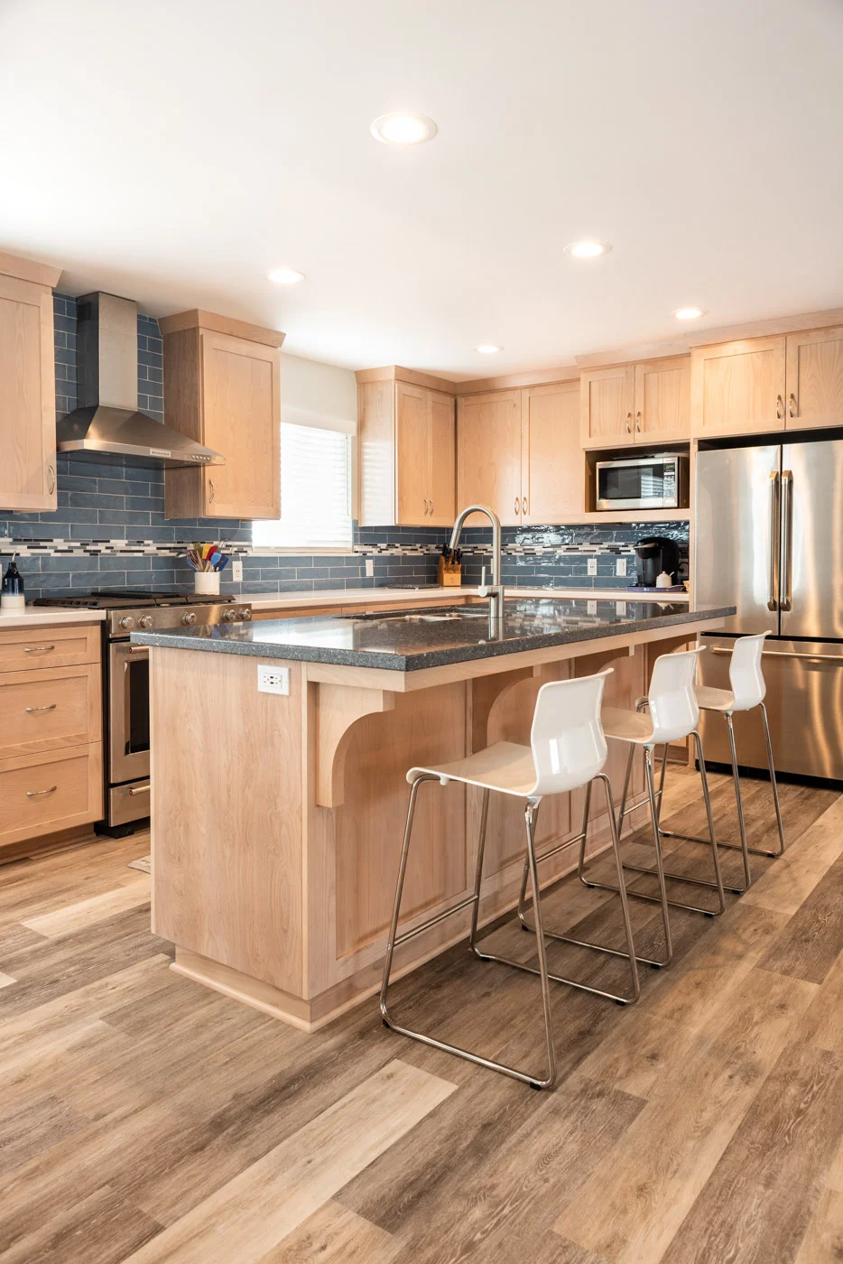 Coastal Contemporary custom kitchen cabinets with natural wood stain and island bar seating