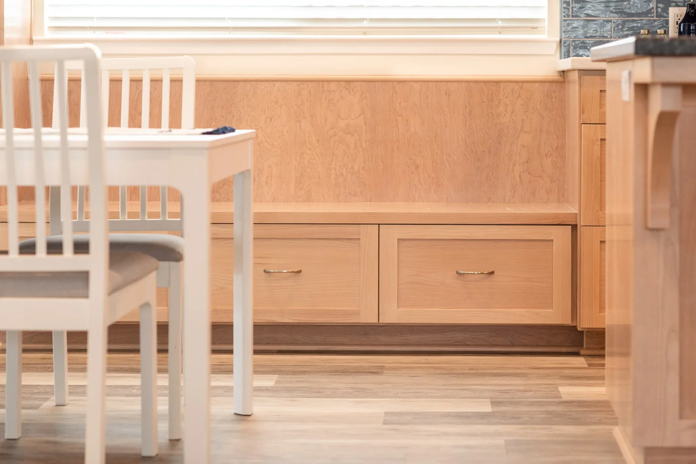 Coastal Contemporary custom kitchen cabinets with natural wood stain and built in bench