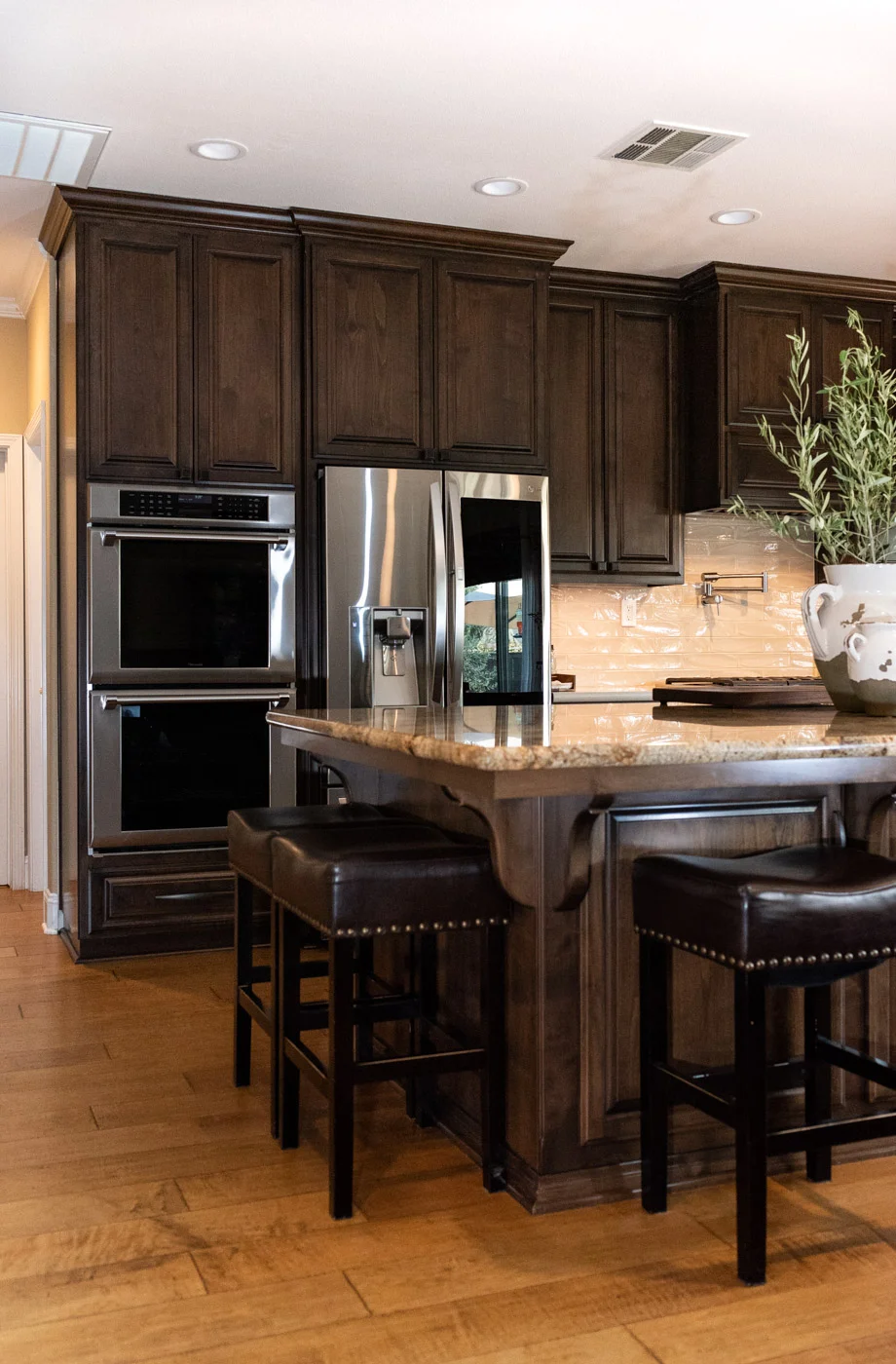 Traditional Mediterranean kitchen with dark wood stain cabinets and double ovens