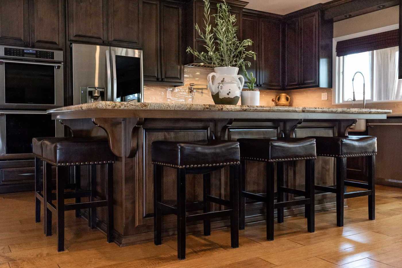 Traditional Mediterranean kitchen with dark wood stain cabinets and large island