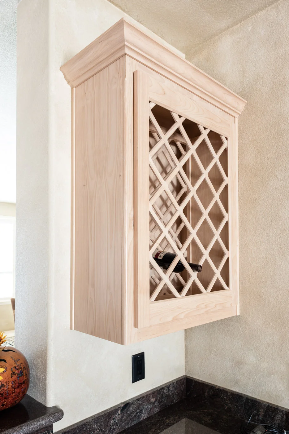 Simple Southwestern custom kitchen cabinets in white washed wood stain with custom wine rack storage