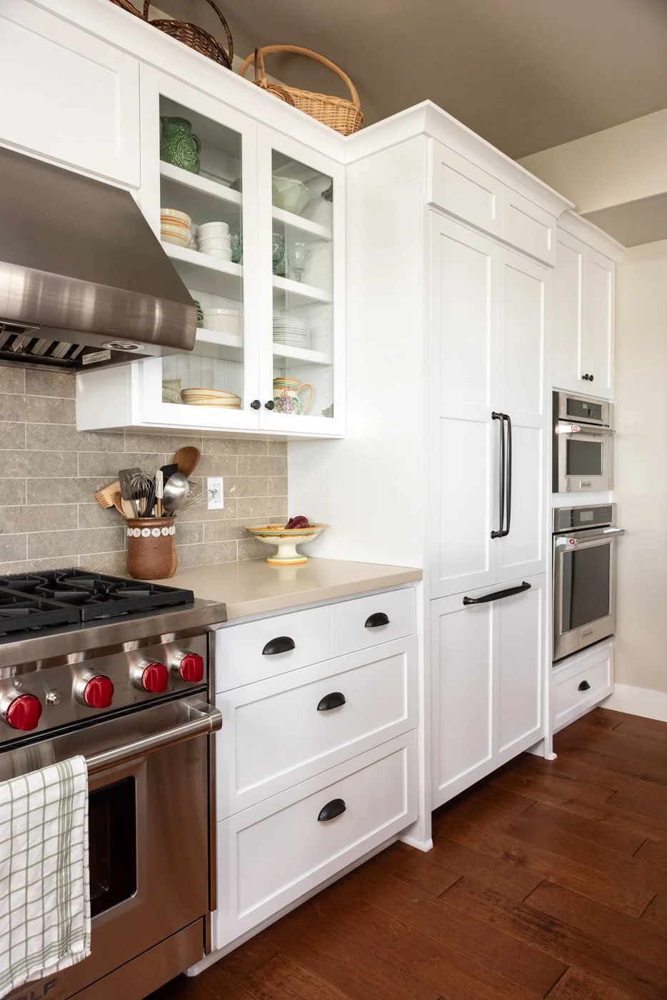 Coastal Craftsman kitchen with custom white painted shaker cabinets and refrigerator door panel