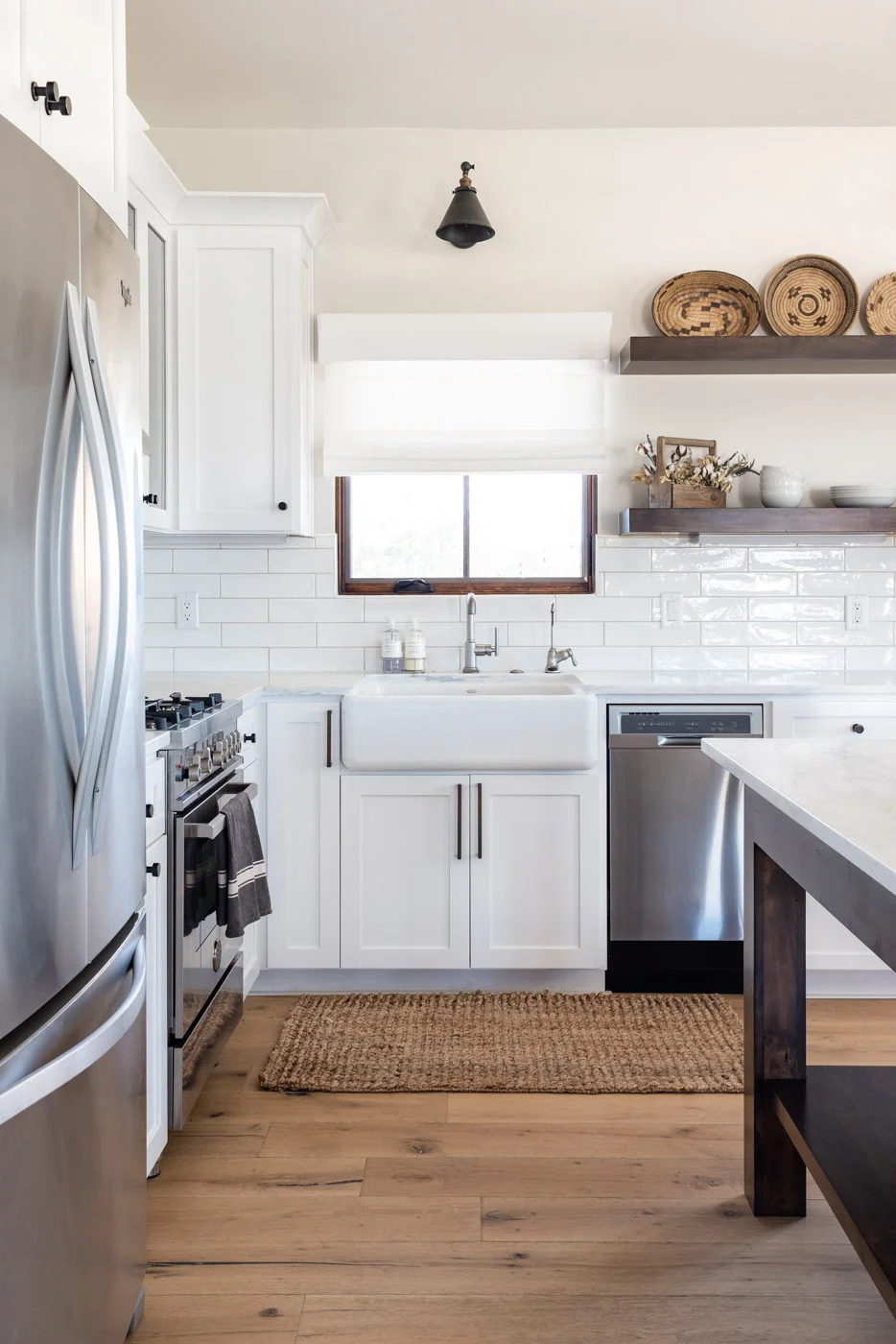 Vineyard Guest House kitchen with custom white painted shaker cabinets farmhouse sink and open shelving