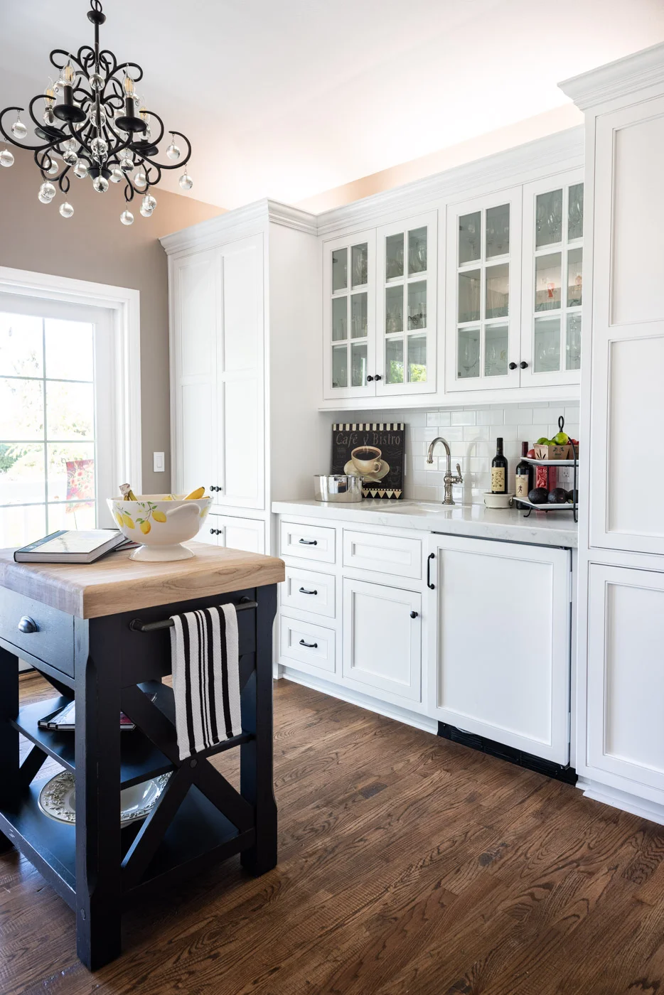 A tea room single-wall kitchen layout used as a home bar with custom white painted cabinets