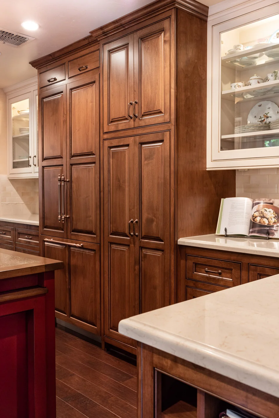 English Country custom kitchen cabinets with wood refrigerator door panels