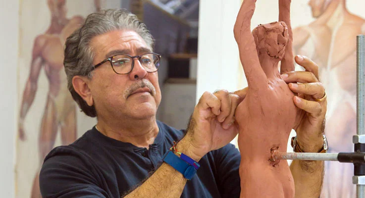 Teale Street student Dan Romero refines his sculpture of a yogini in tree pose. Photos by Inae Bloom