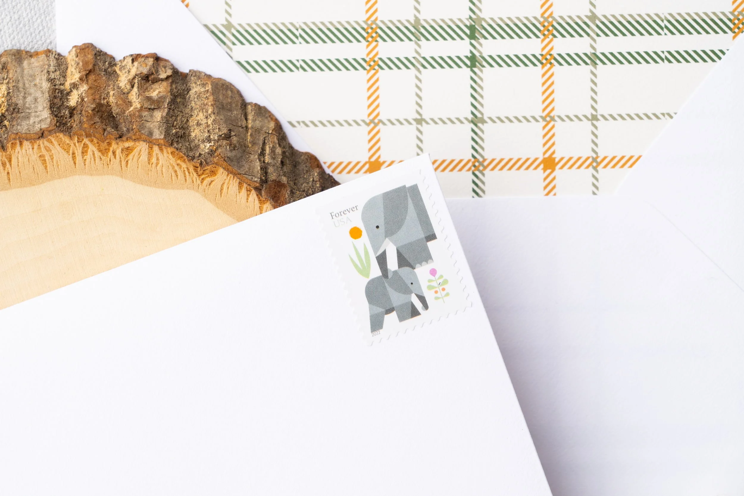 Outdoor-inspired first birthday stationery featuring watercolor camping motifs, layered textures, die-cut campfire details, and cozy woodland charm.