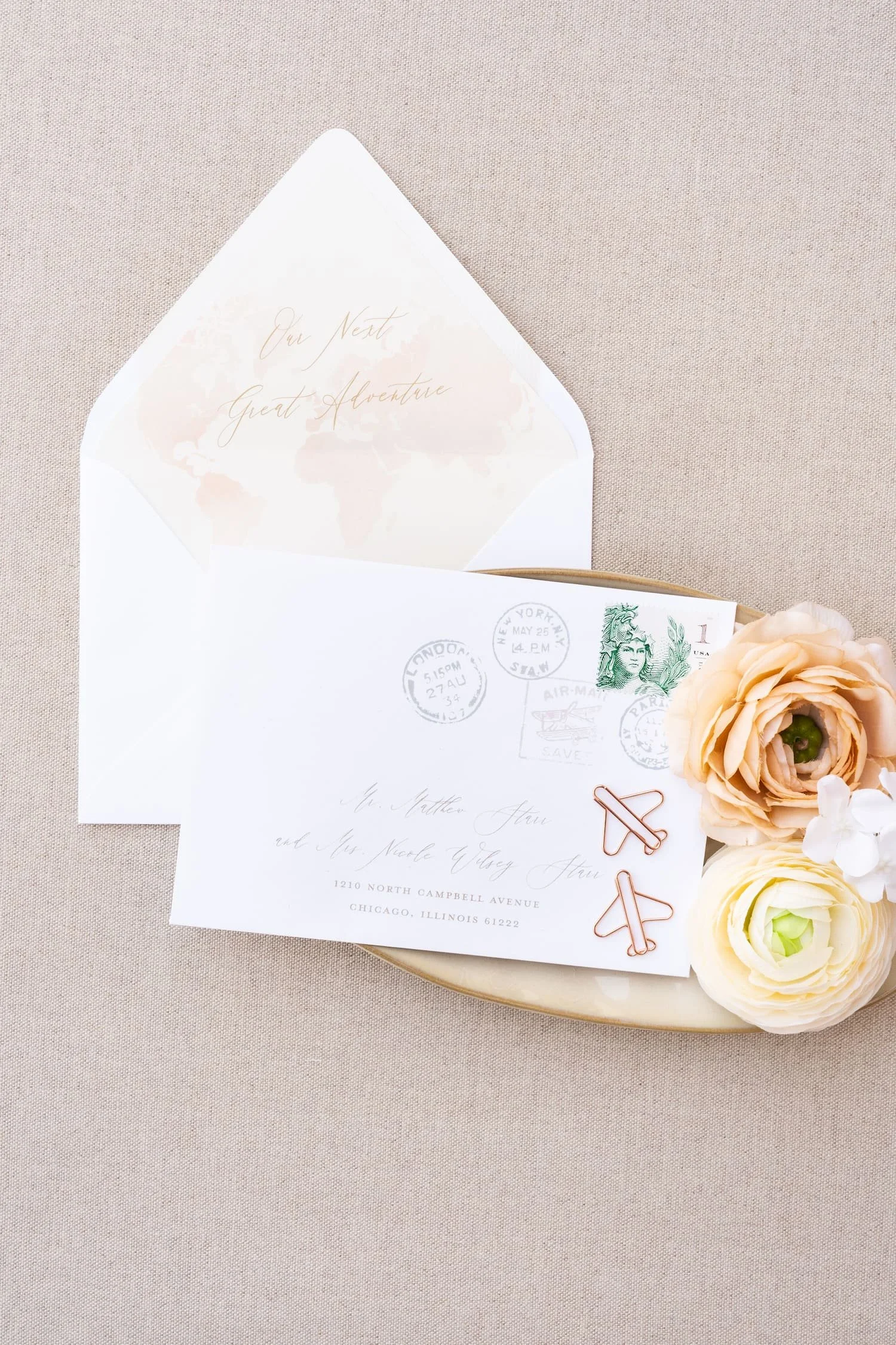 Baby shower invitation envelope featuring custom passport stamp artwork inspired by travel, paired with a modern design celebrating a couple's next great adventure as they welcome a new baby.