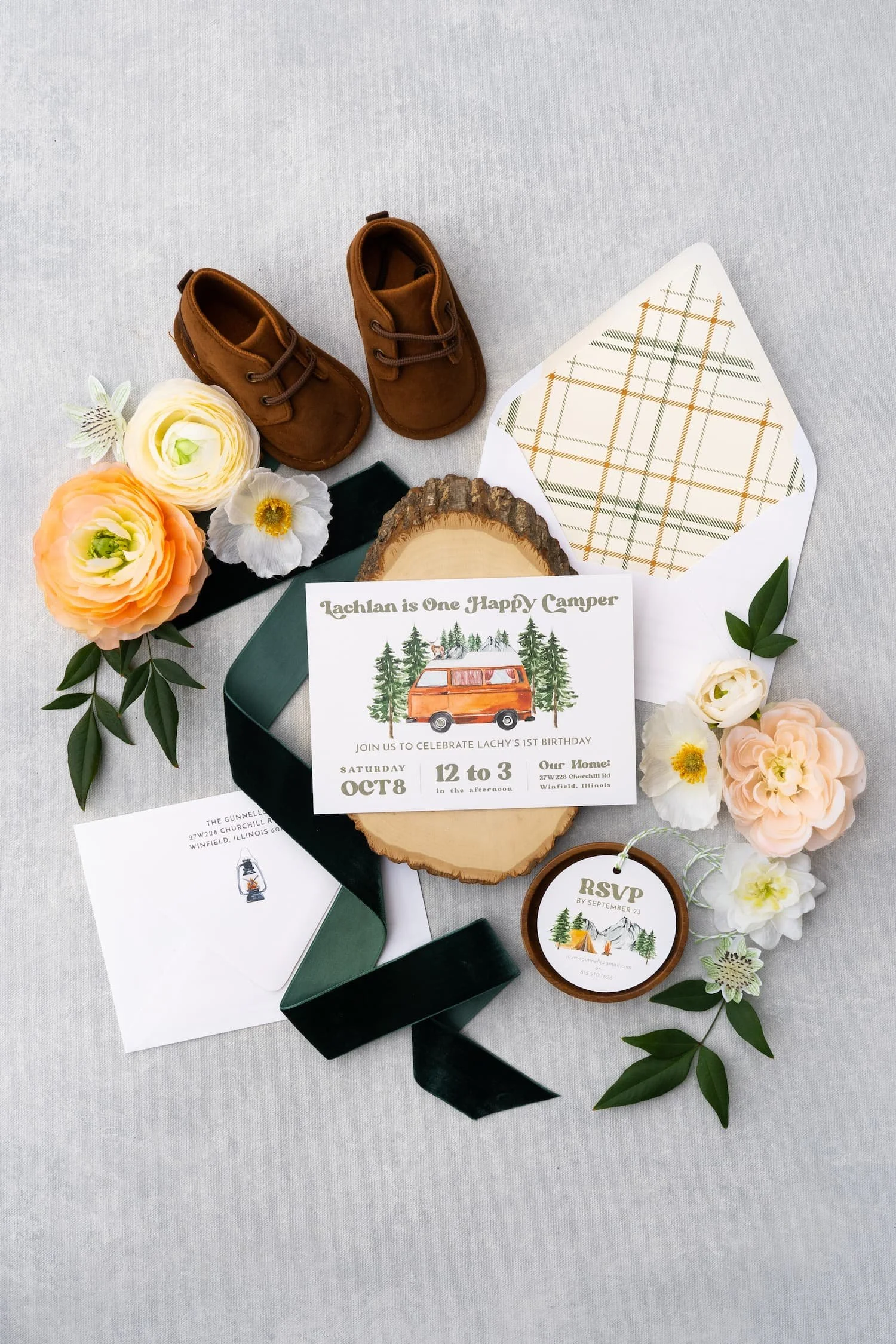Camping-themed first birthday stationery suite featuring watercolor outdoor details, rustic textures, plaid patterns, and playful camp-inspired paper goods.