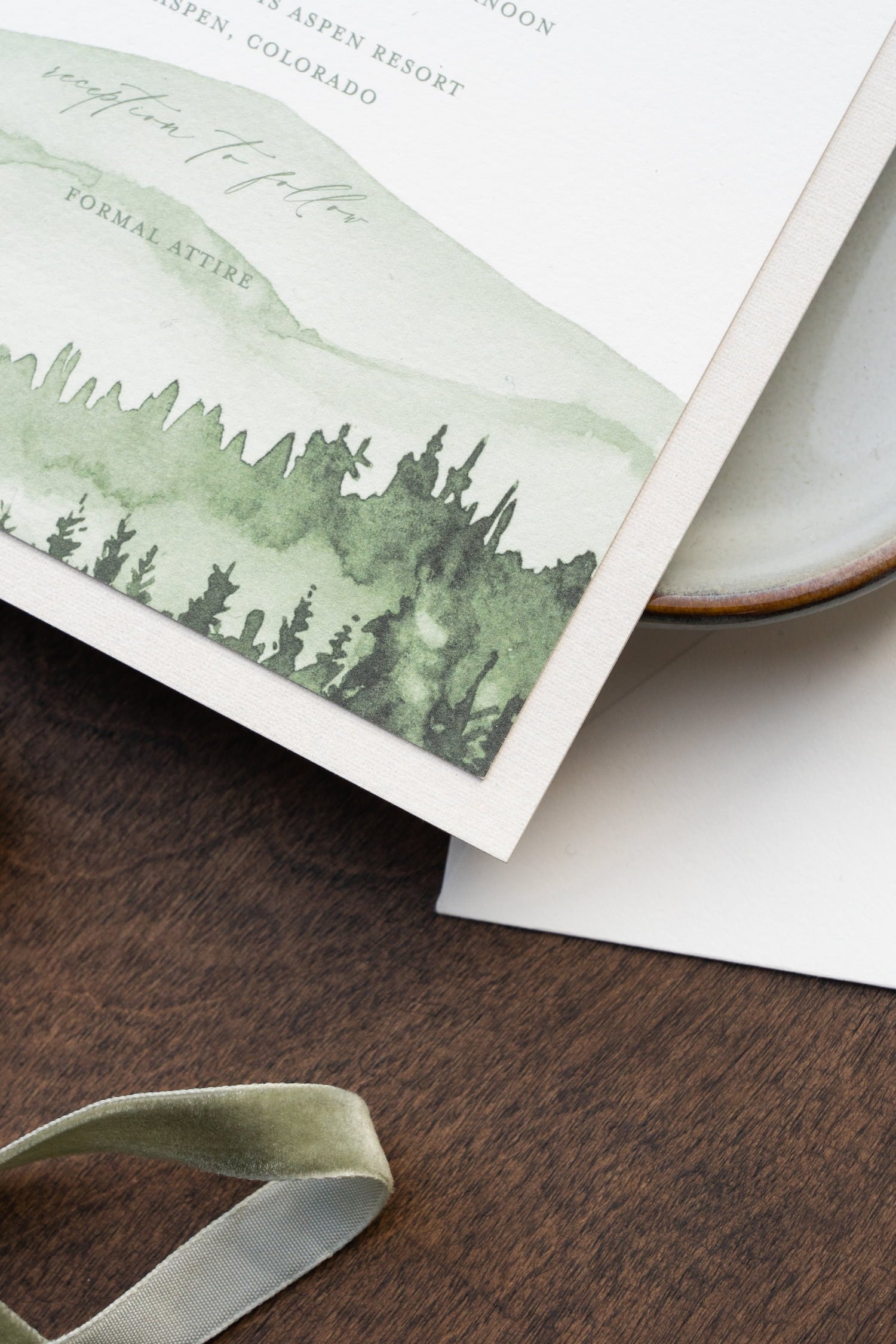 Elegant destination wedding invitation suite featuring watercolor mountain artwork, blush and white flowers, textured paper details, and luxury finishing touches inspired by Aspen, Colorado.