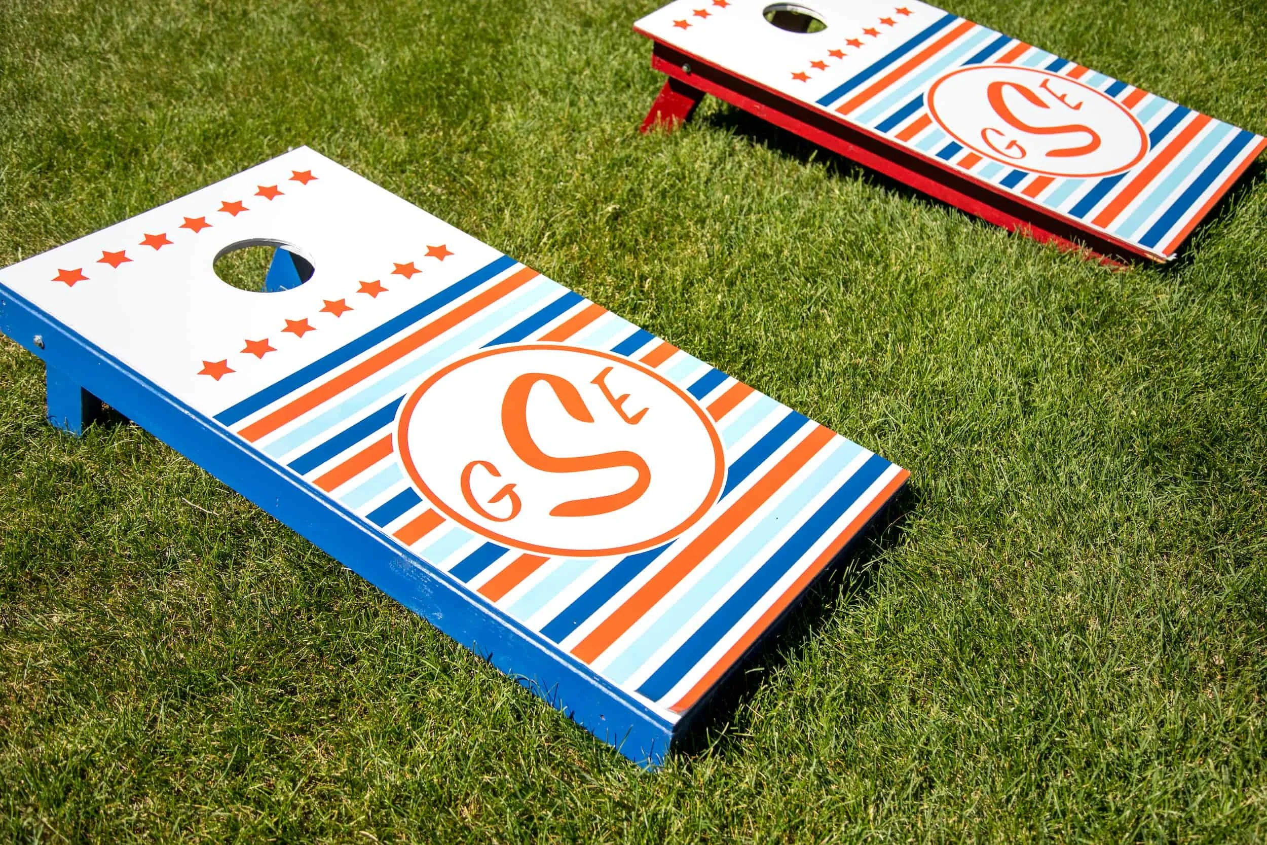 Red, white, and blue airplane birthday party featuring aviation-themed decor, custom signage, custom cornhole, and playful details for a two- and four-year-old celebration.