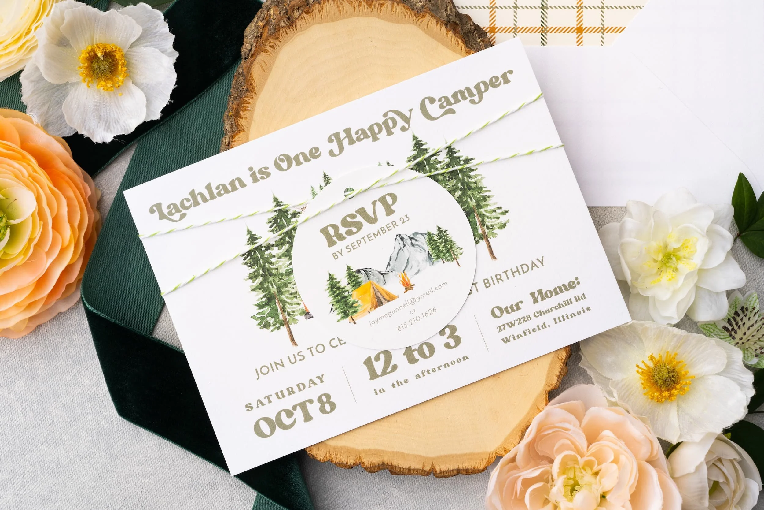 Outdoor-inspired first birthday stationery featuring watercolor camping motifs, layered textures, die-cut campfire details, and cozy woodland charm.