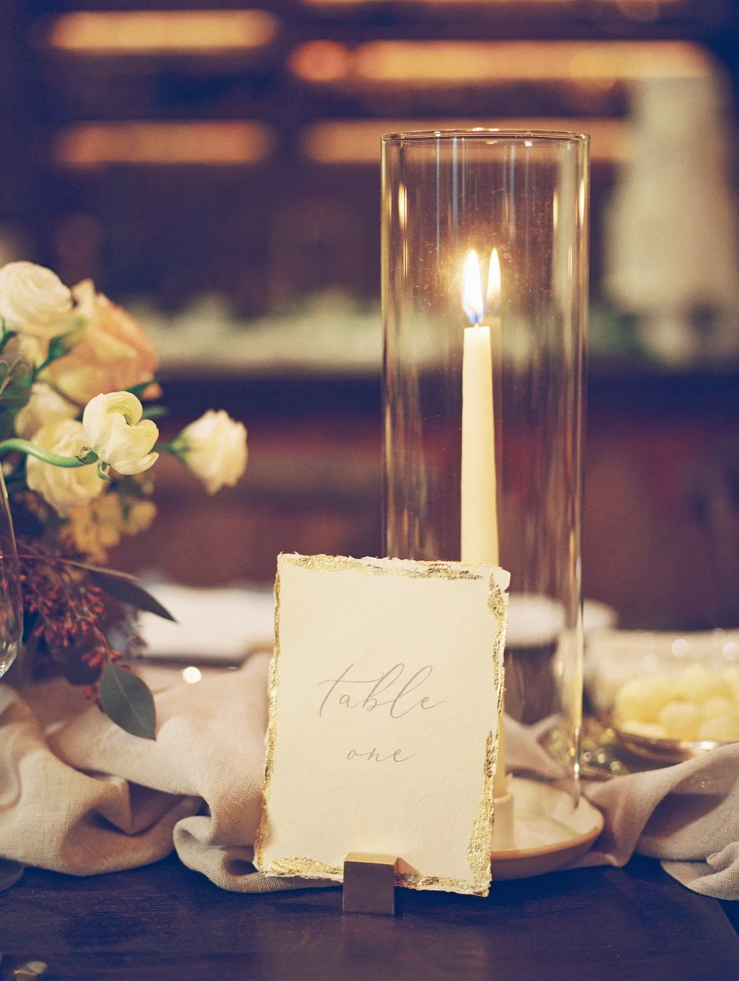 Elegant wedding table numbers with gold leaf edges, designed to complement a luxurious winter mountain reception in Aspen.