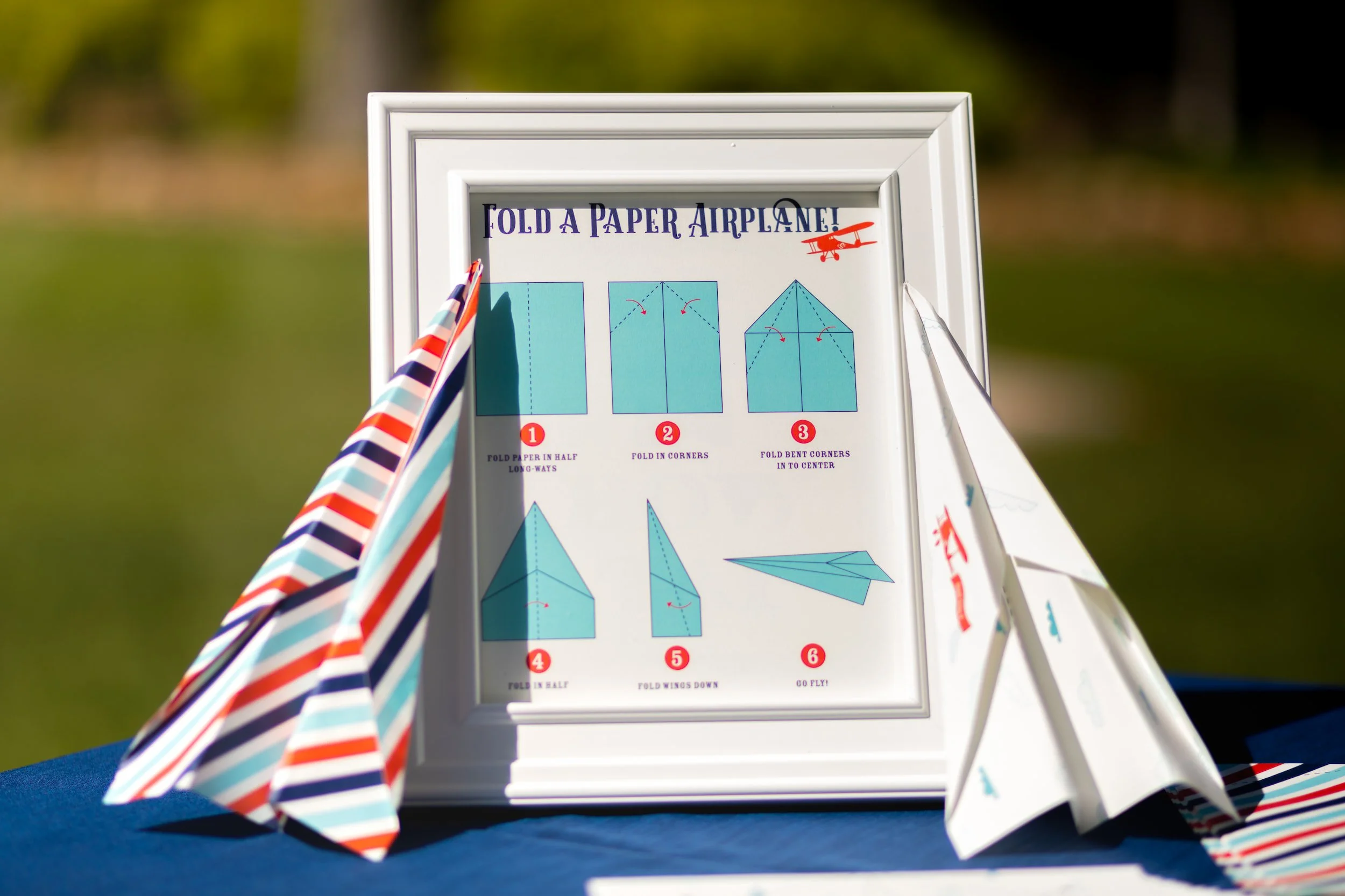 Red, white, and blue airplane birthday party featuring aviation-themed decor, custom paper airplanes, and playful details for a two- and four-year-old celebration.