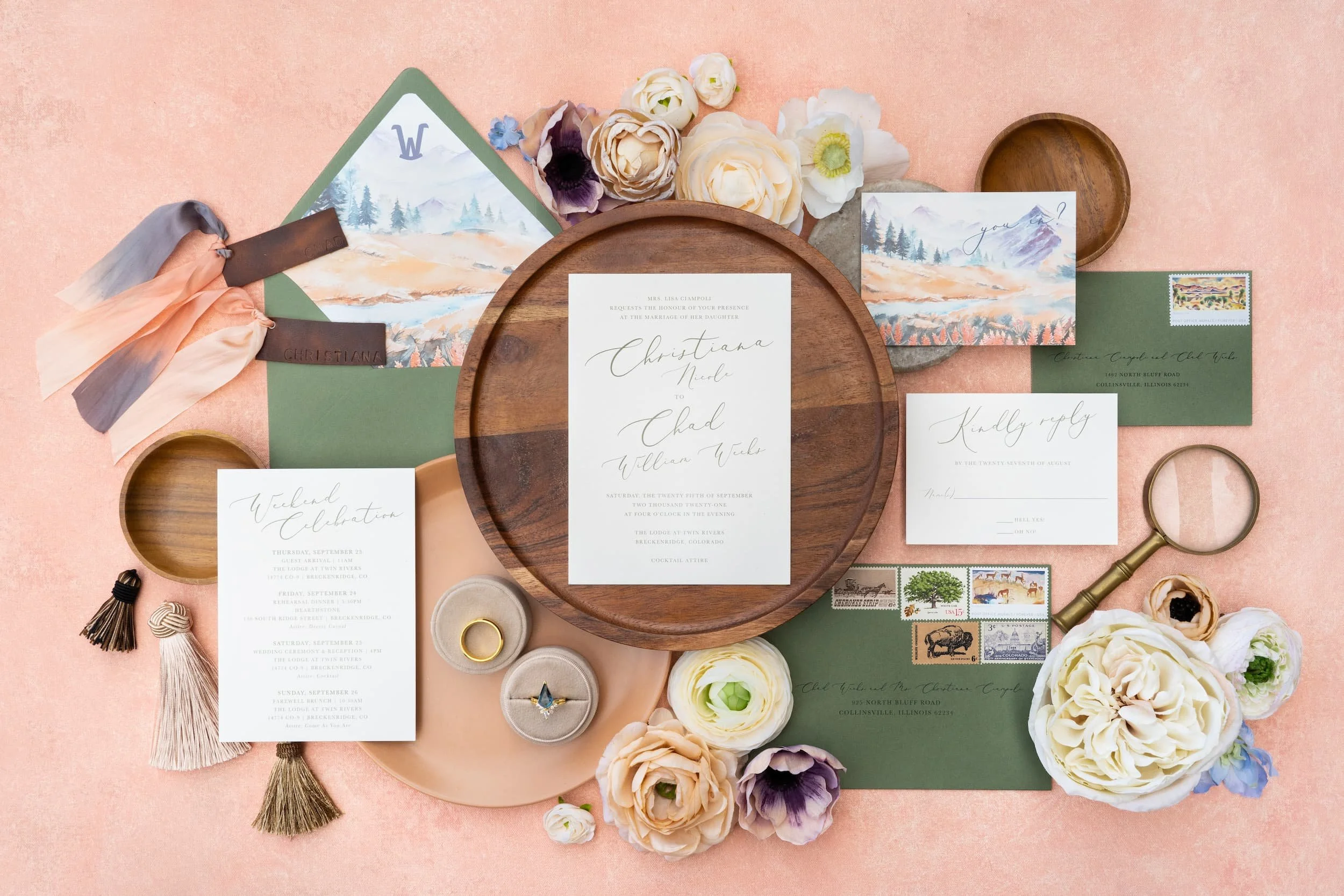Luxury mountain ranch wedding invitation suite featuring watercolor autumn mountain landscapes, peach and sage color palette, modern script typography, handmade paper, and Western-inspired details arranged in an elegant flat lay.