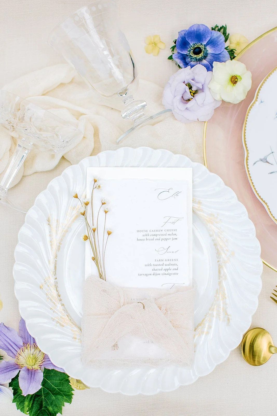 Handmade paper wedding menus wrapped in plant-dyed silk, reflecting the natural textures and wildflower-inspired colors of a Boulder Flower Farm wedding.