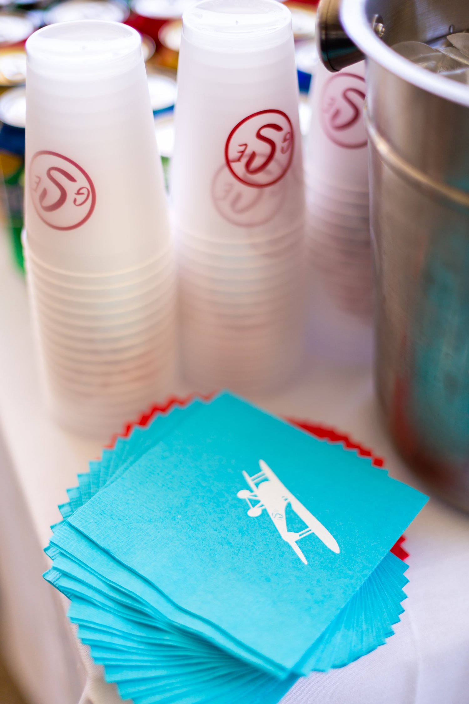 Red, white, and blue airplane birthday party featuring aviation-themed decor, custom cocktail napkins and reusable cups, and playful details for a two- and four-year-old celebration.
