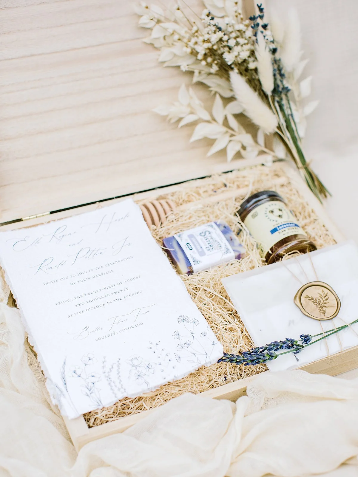 Wildflower-inspired wedding invitation suite for Boulder Flower Farm featuring handmade cotton paper, flowing calligraphy, purple and peach floral illustrations, and butter-yellow accents.