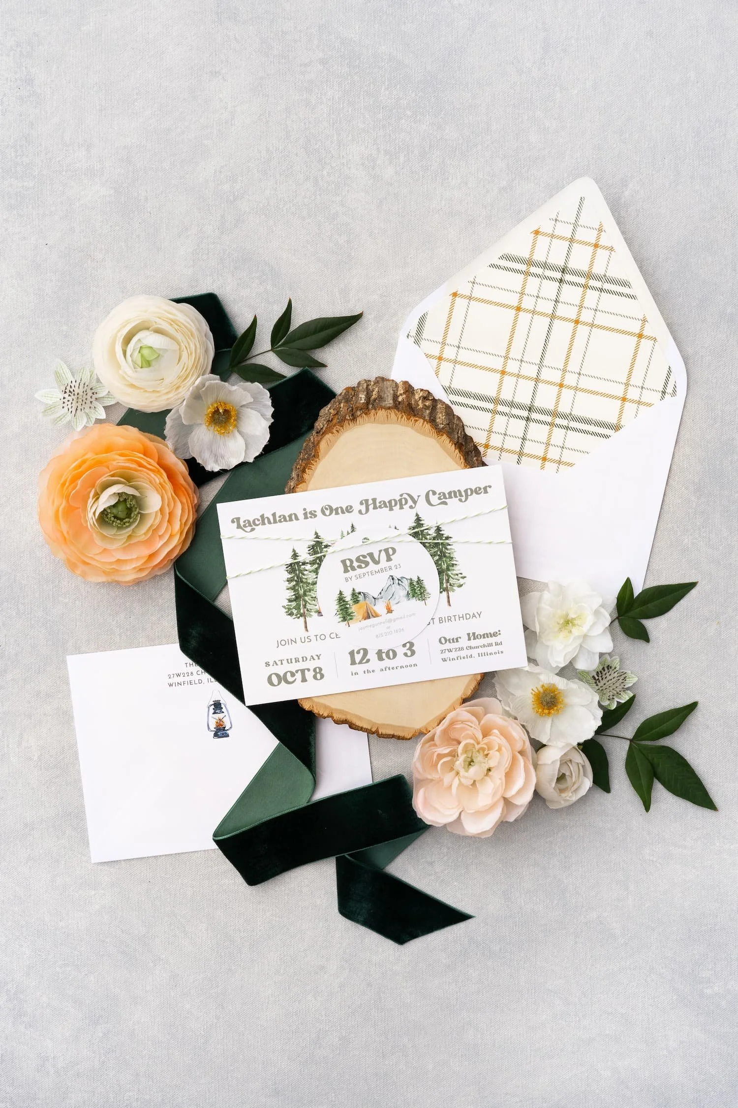 Outdoor-inspired first birthday stationery featuring watercolor camping motifs, layered textures, die-cut campfire details, and cozy woodland charm.