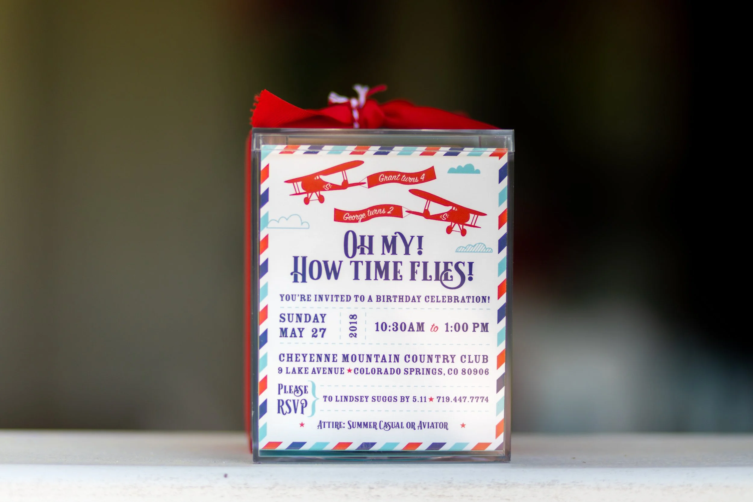 Red, white, and blue airplane birthday party featuring aviation-themed decor, custom boxed acrylic invitations, and playful details for a two- and four-year-old celebration.