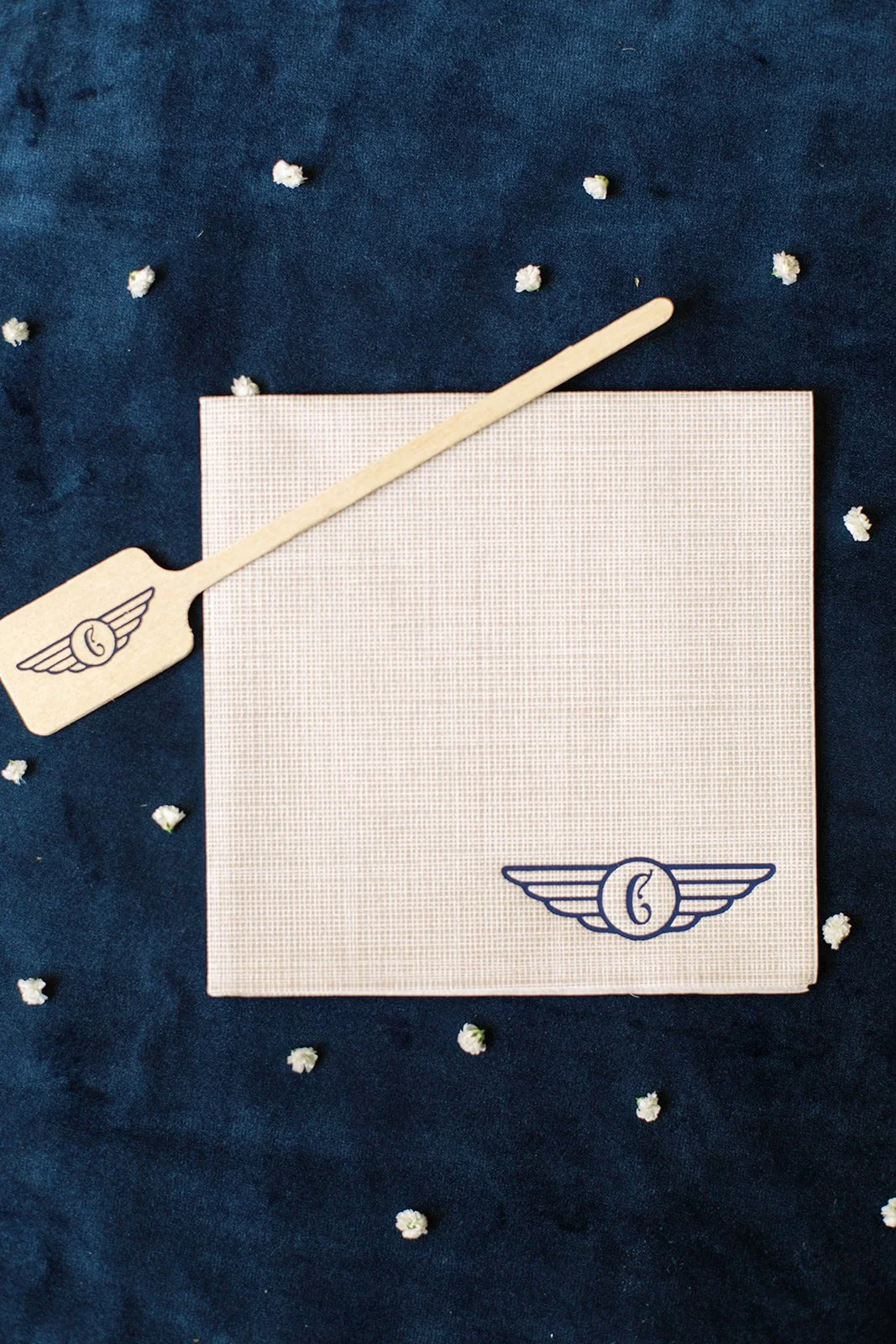 Custom baby shower cocktail napkins featuring travel-inspired artwork and modern typography in navy, light blue, and white.
