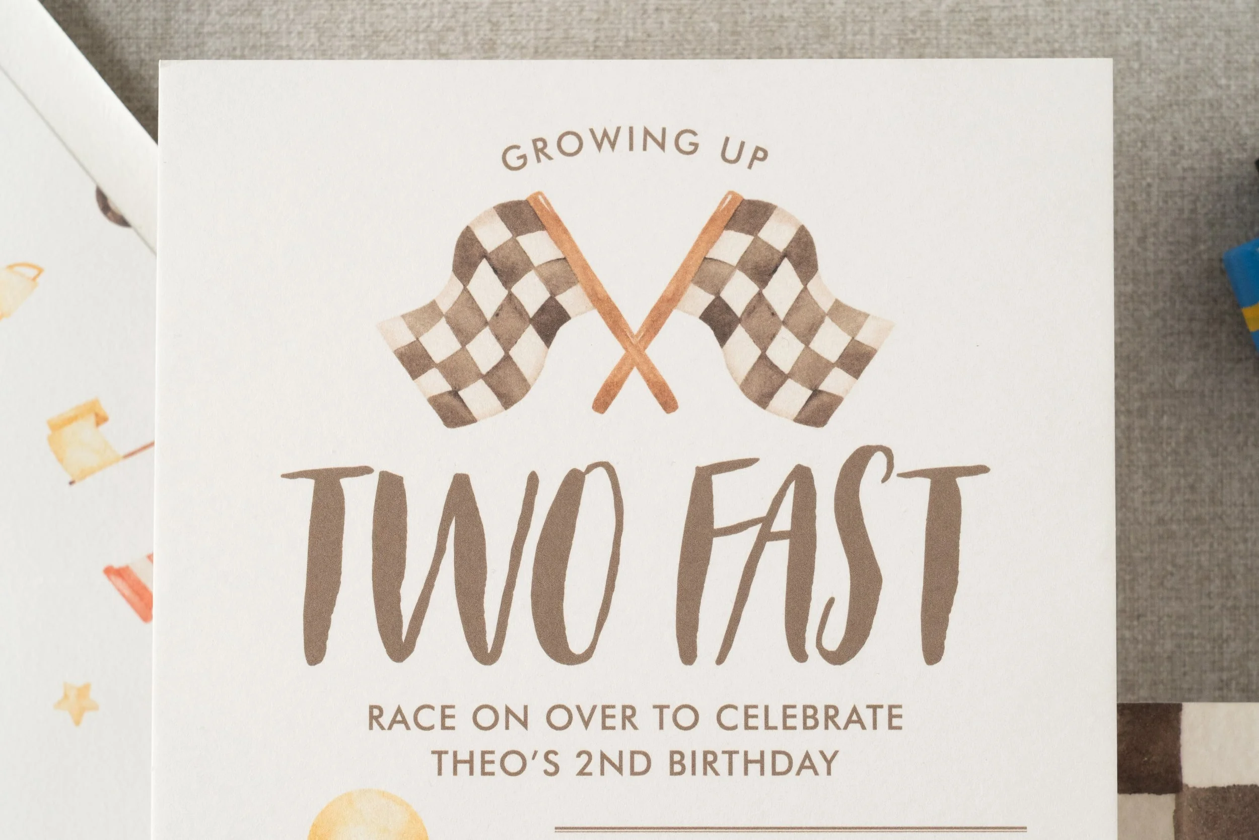 “Two Fast” race car birthday invitation suite for a two-year-old boy featuring watercolor race car illustrations, black-and-white check details, and vintage-inspired racing stamps.