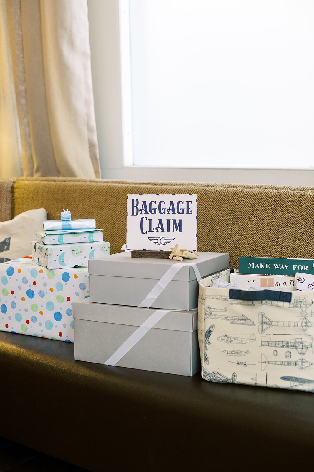 Custom "Baggage Claim" sign directing guests where to leave gifts, designed with a modern travel-inspired aesthetic in navy, light blue, and white.