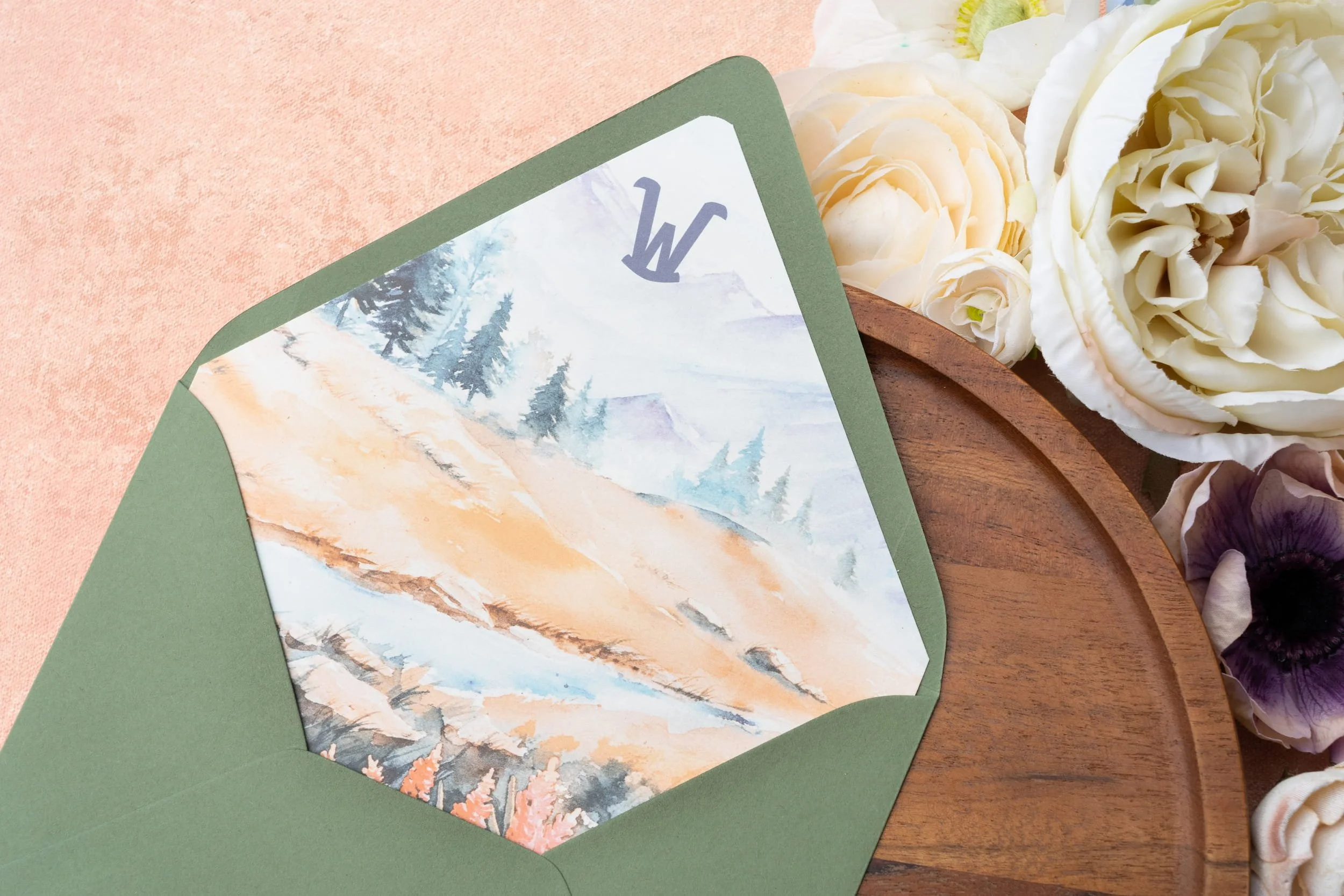 Envelope featuring a custom liner with a ranch-style brand inspired by iconic Western landscapes, paired with coordinating sage and peach stationery.